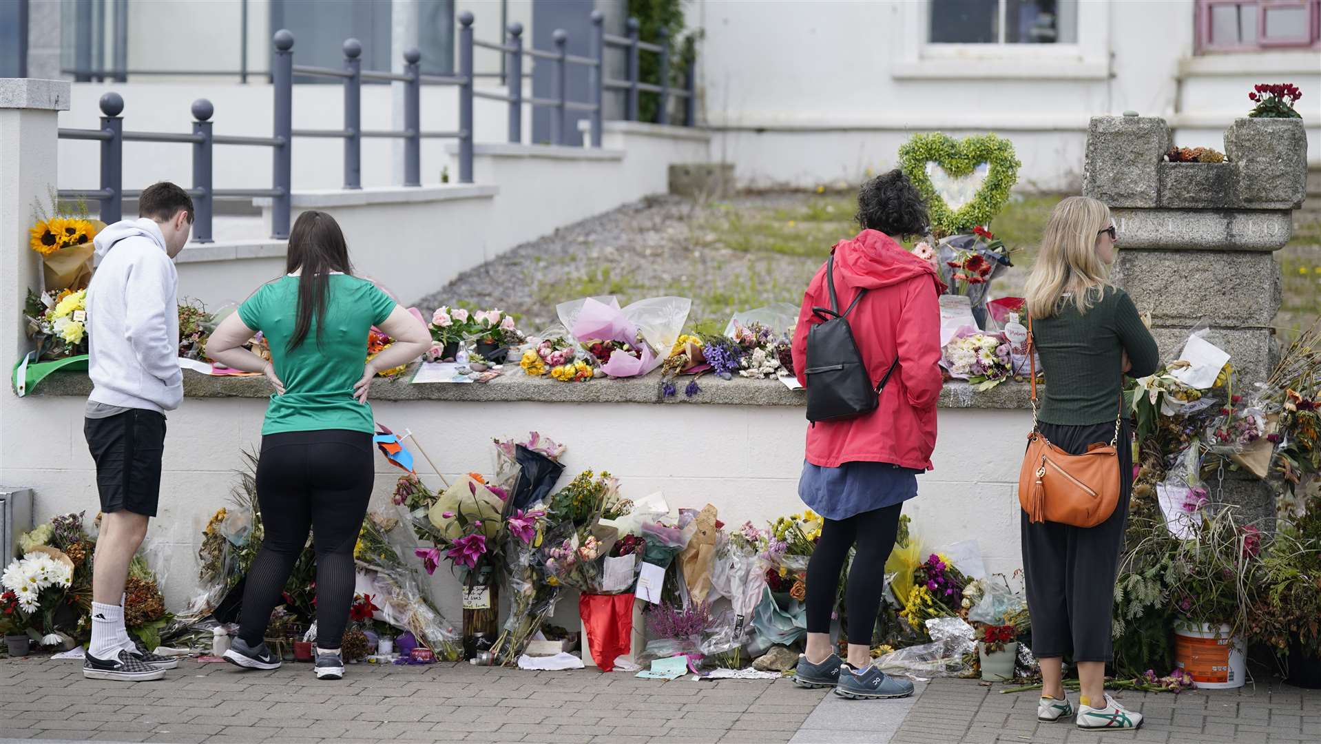 People looking at flowers outside Sinead O’Connor’s former home in Bray, Co Wicklow, ahead of the 56-year-old’s funeral on Tuesday (Niall Carson/PA)