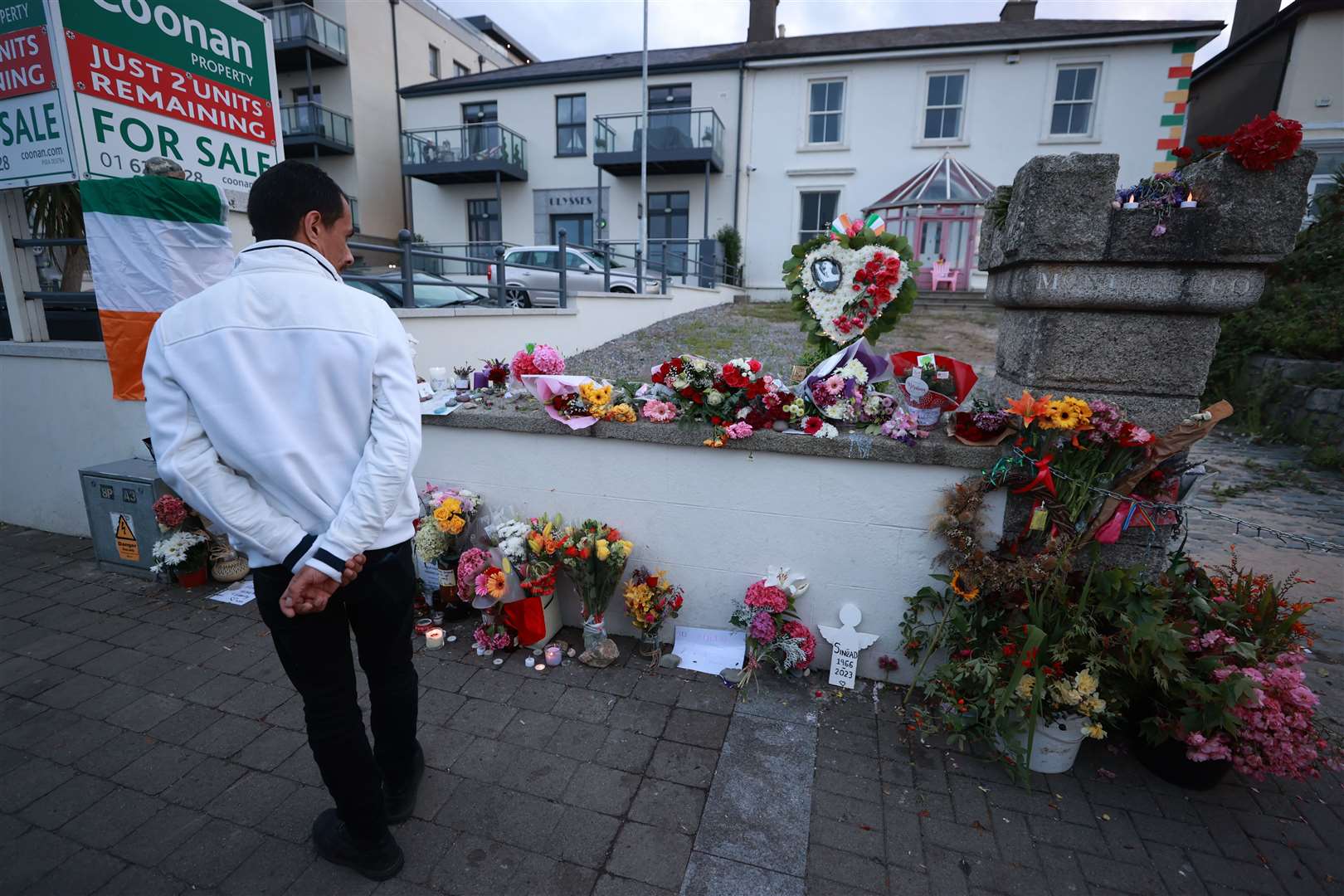 A man looks at flowers outside Sinead O’Connor’s former home in Bray, Co Wicklow (Liam McBurney/PA)