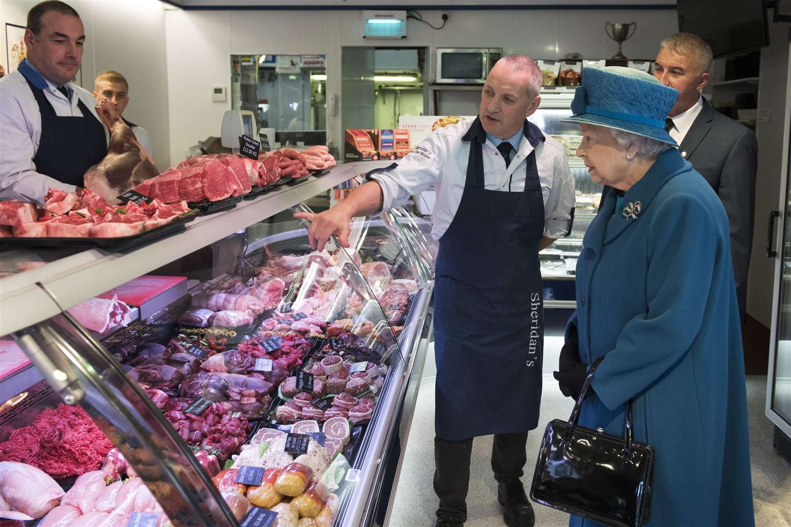 Queen Elizabeth II speaks with the co-owners of HM Sheridan, Barry Florence and John Sinclair (John Linton/PA)