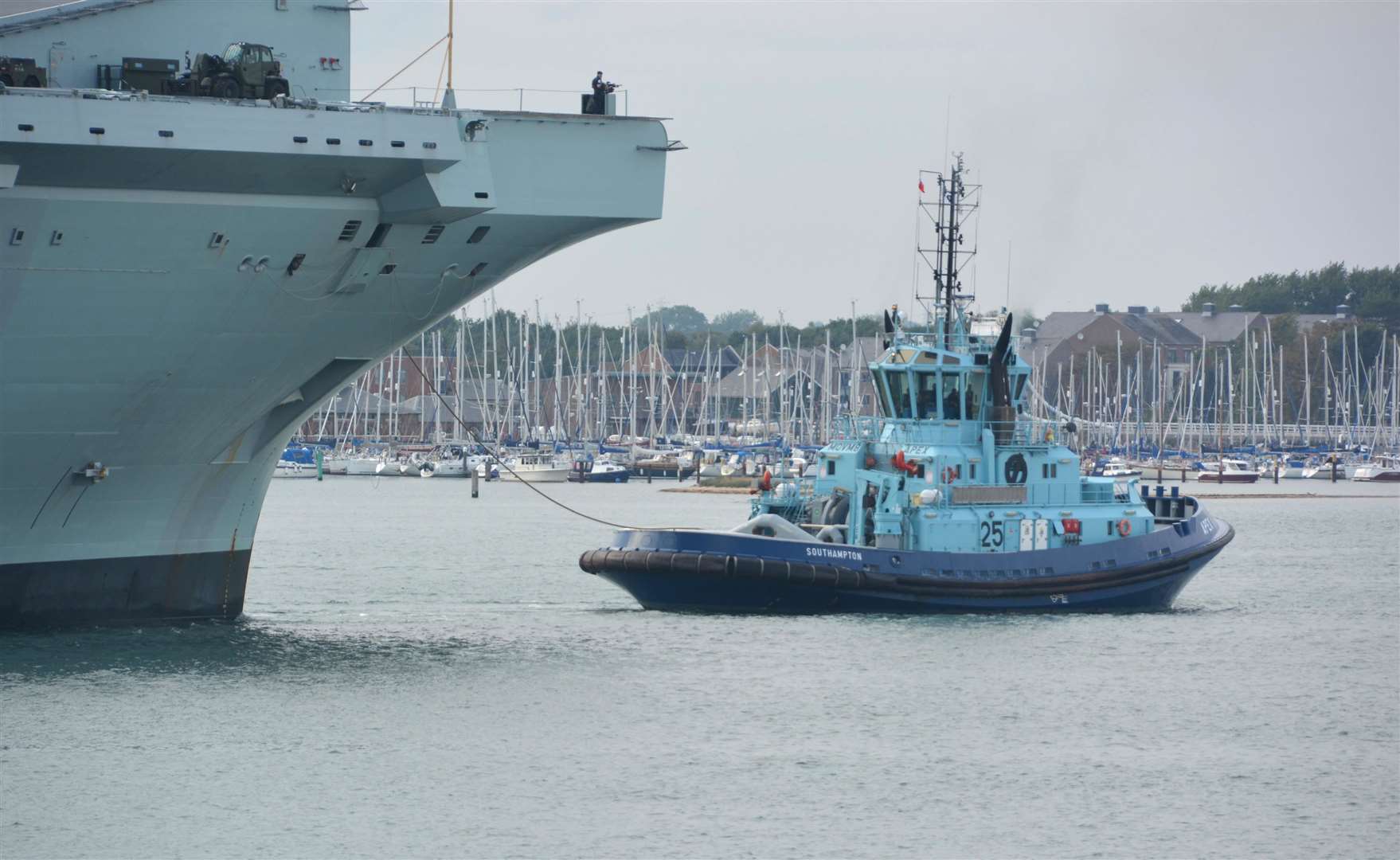 The tug Apex helps the carrier return to Portsmouth (Ben Mitchell/PA Wire)