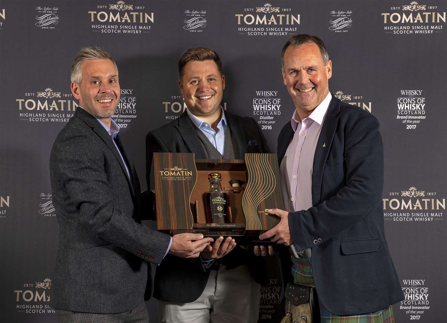 Neil Fenwick (centre) celebrates winning the title with Stephen Bremner of sponsors Tomatin and event organiser Stuart McColm.
