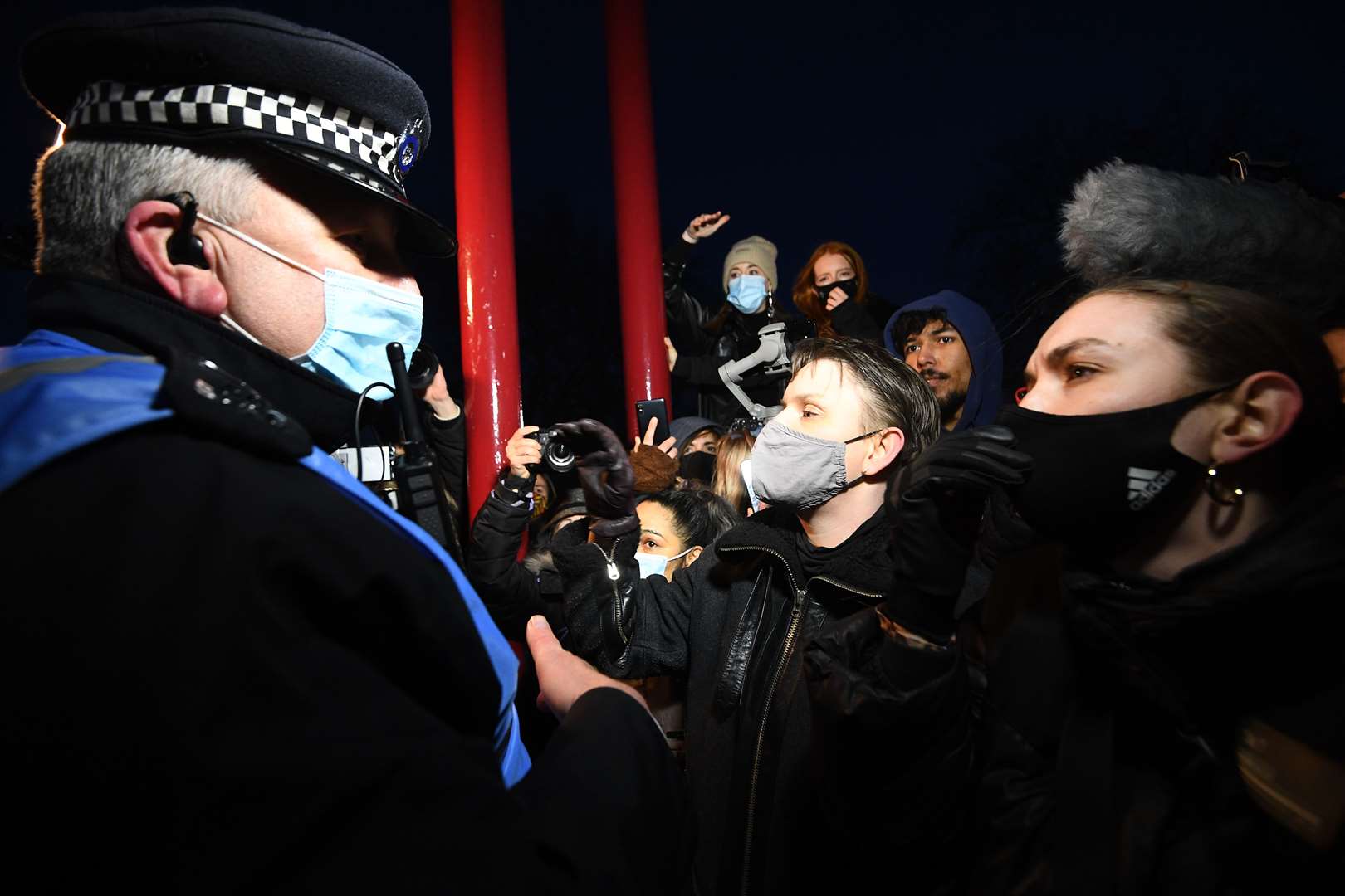 People talk to police as they gather at the bandstand in Clapham Common (Vicrtoria Jones/PA)