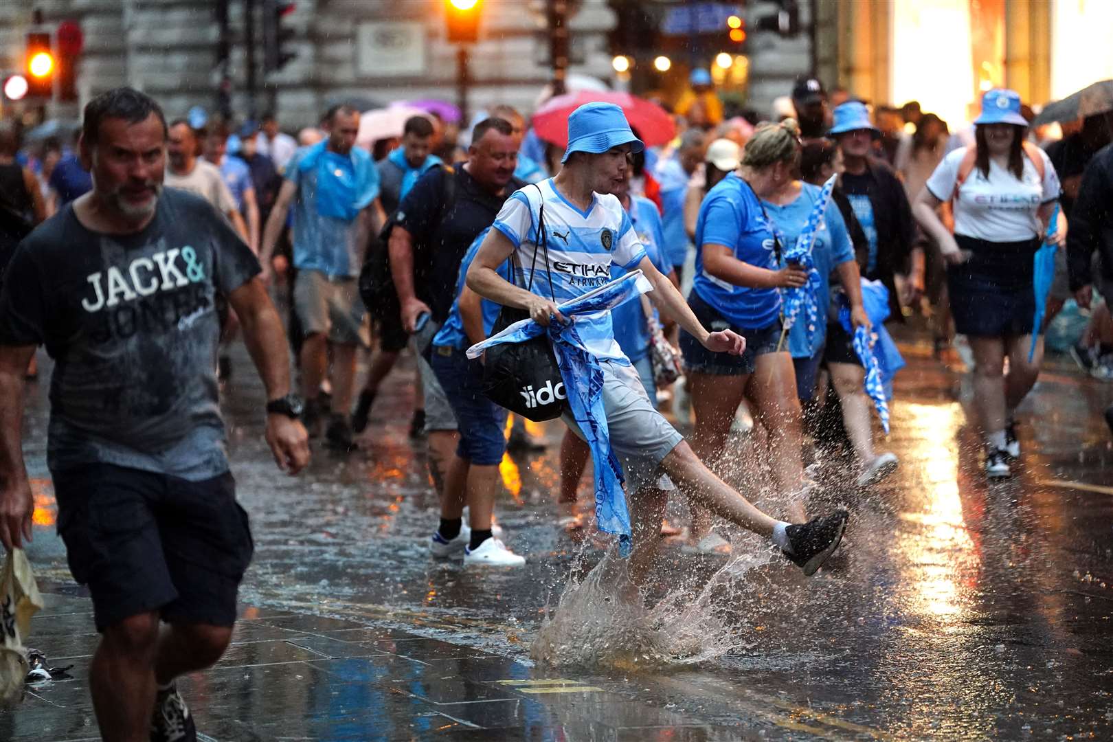 Manchester City fans in the rain during the Treble Parade in Manchester (David Davies/PA)