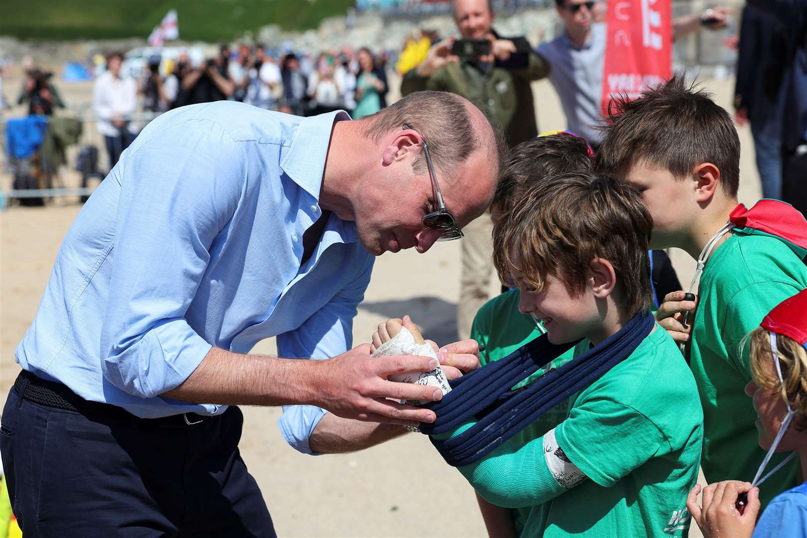 William signs the cast of Felix Kanes, a member of Holywell Bay Surf Life Saving Club (Toby Melville/PA)