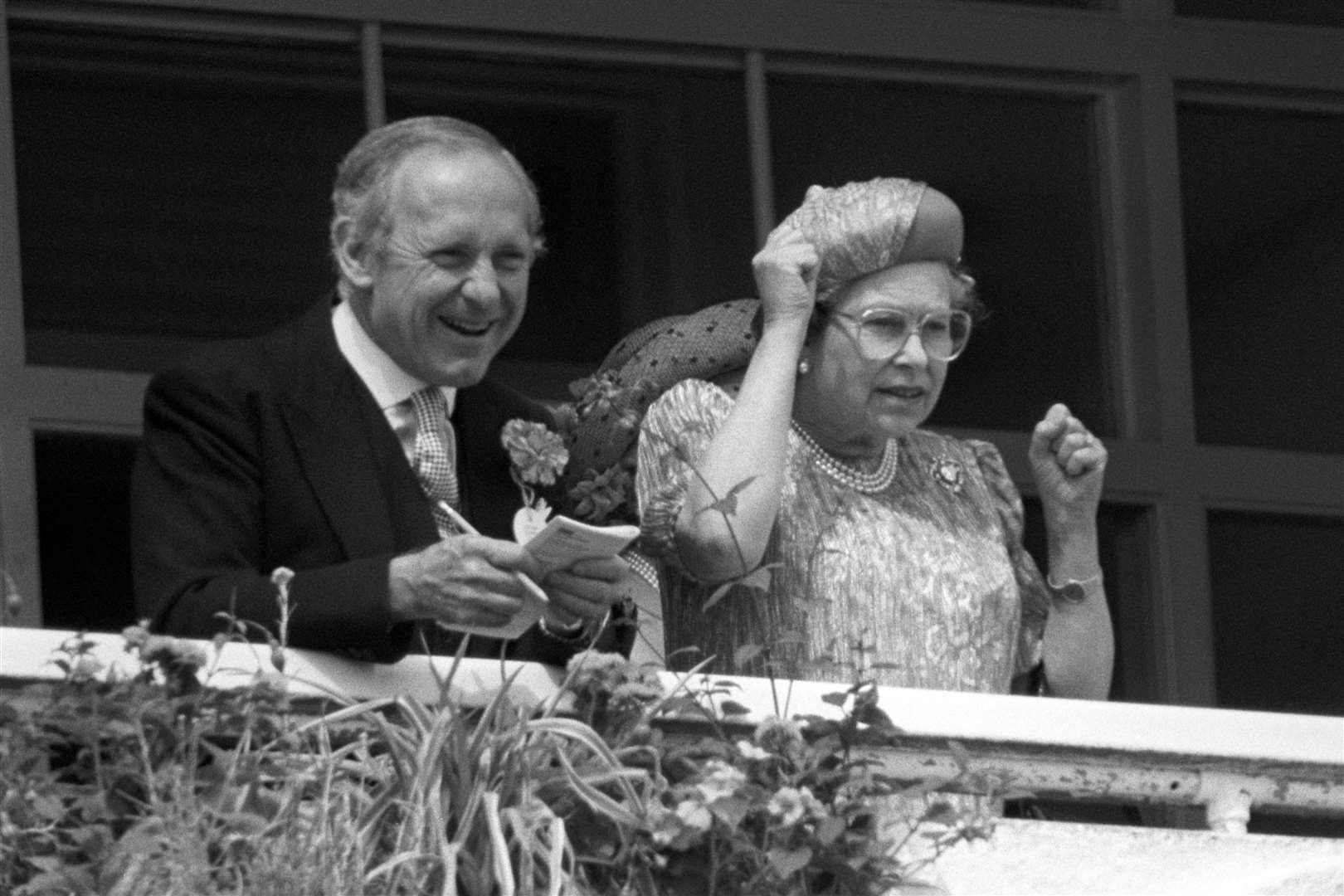 Cheering on her horse with private secretary Sir William Heseltine from the royal box at Epsom in 1989 (Adam Butler/PA)