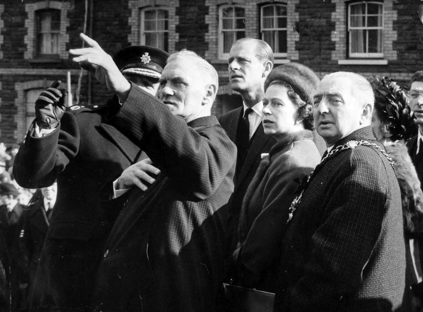 The Queen and the Duke of Edinburgh follow the pointing finger of local resident, councillor Jim Williams, who lost seven members of his family in the Aberfan disaster (Archive/PA)
