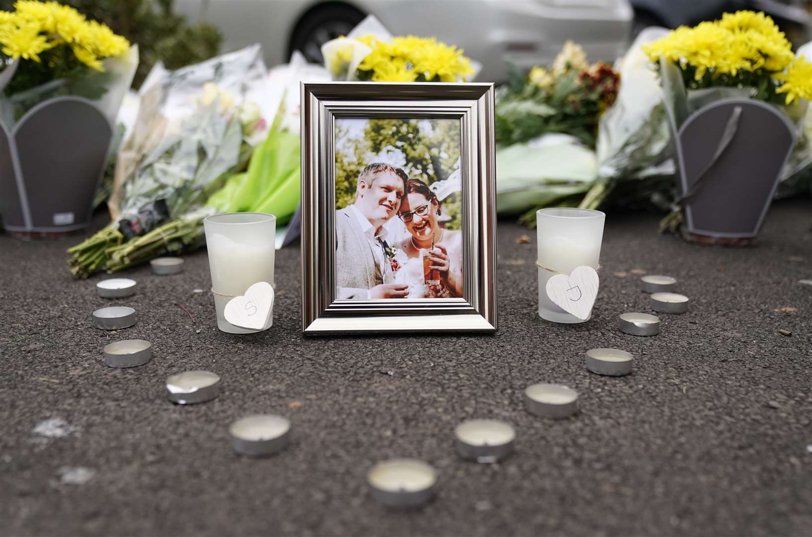Candles and a picture frame next to floral tributes left near the scene in Norton Fitzwarren (Andrew Matthews/PA)