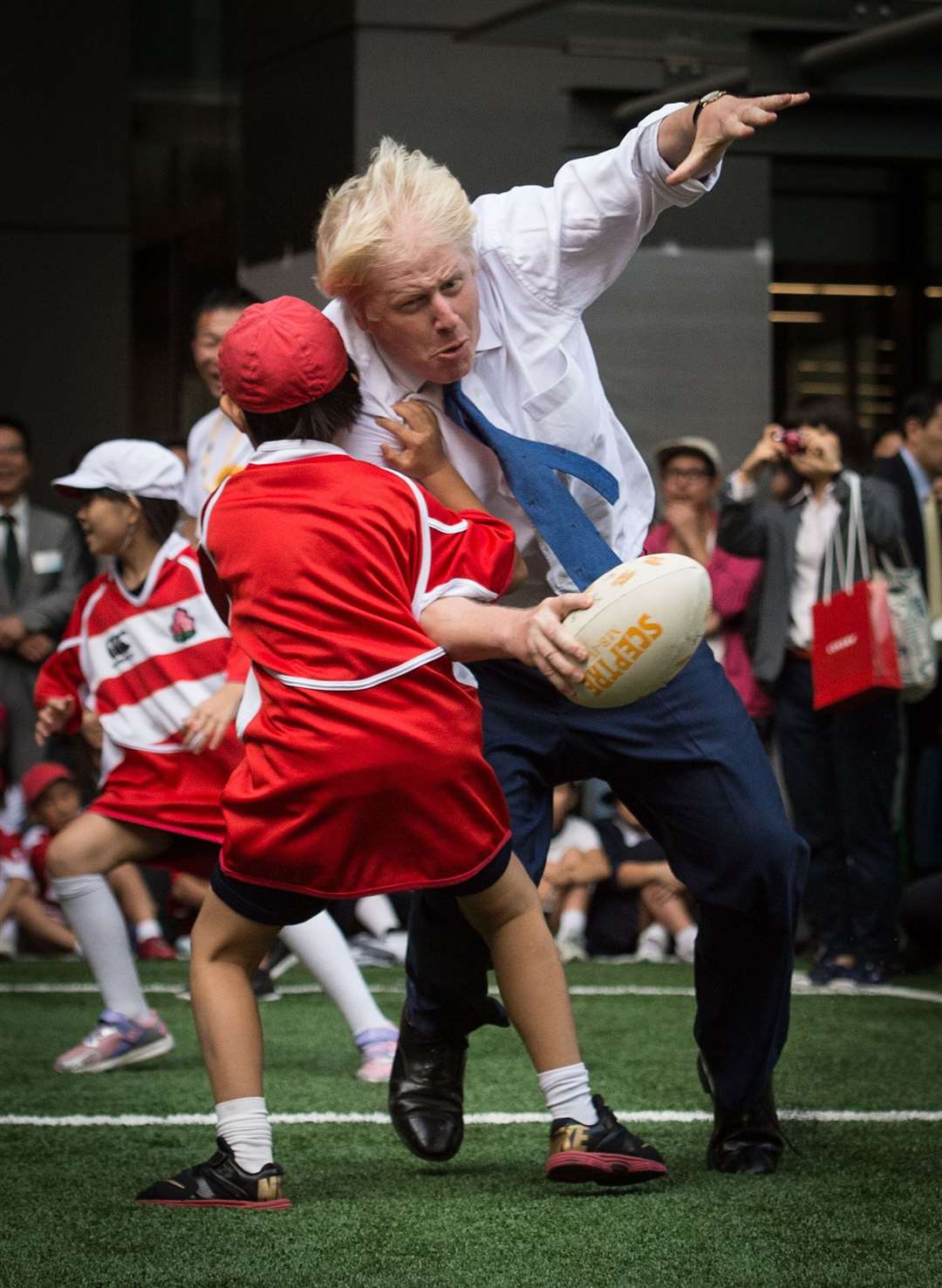 Giving no quarter, Mr Johnson joined a street rugby tournament in Tokyo during a visit in 2015 when he was mayor of London (Stefan Rousseau/PA)
