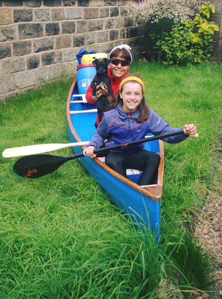 Addi and Athina and pet dog Little MIss Shadow in their canoe called Icarus.