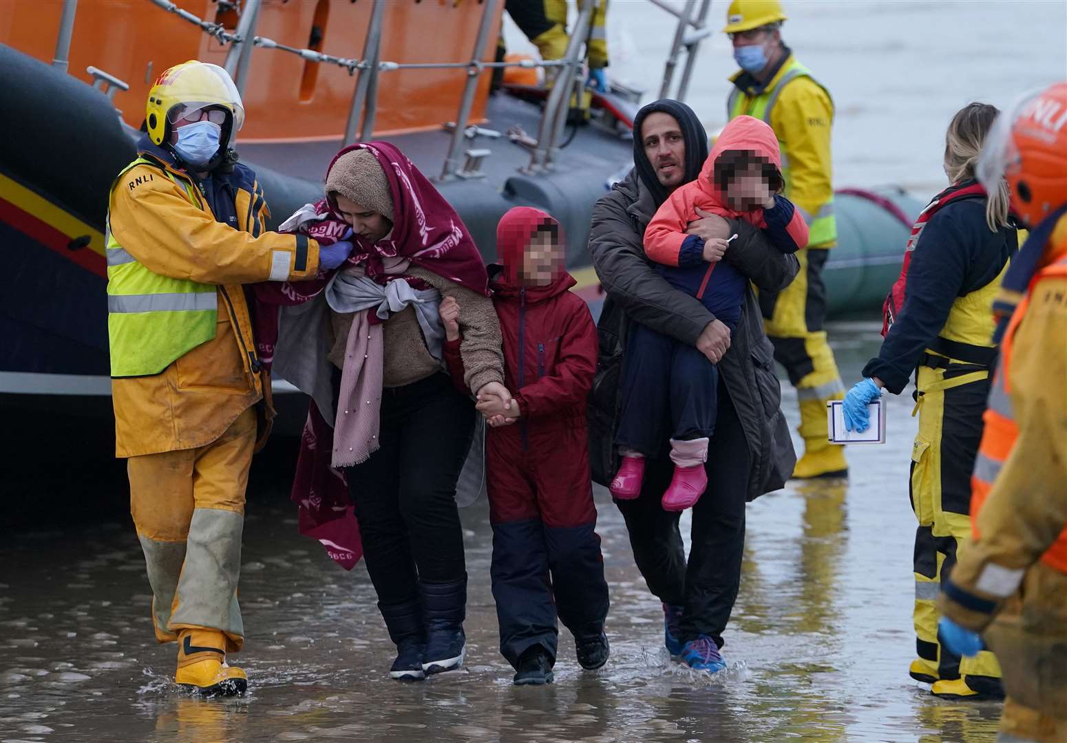 Migrants are helped ashore in Kent (Gareth Fuller/PA)