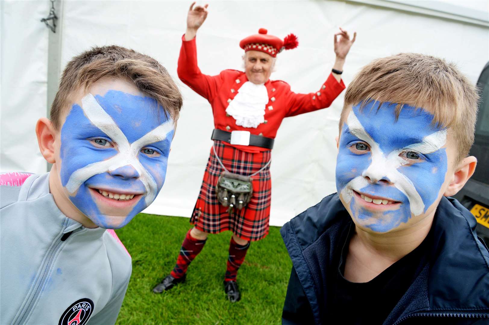 Painted for Scotland were brothers Ally Sutherland (6) and Donnie Sutherland (8) (right) and dressed for Scotland was Gerald Dunlop in MacFarlane tartan....Inverness Highland Games.Picture: Gair Fraser. Image No. 044467..
