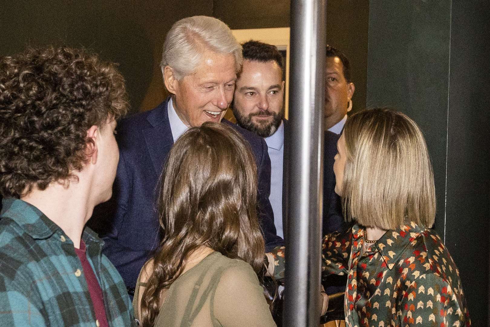 Former US president Bill Clinton and SDLP leader Colum Eastwood MP (centre right) are greeted by patrons at the Guildhall Taphouse (Liam McBurney/PA)