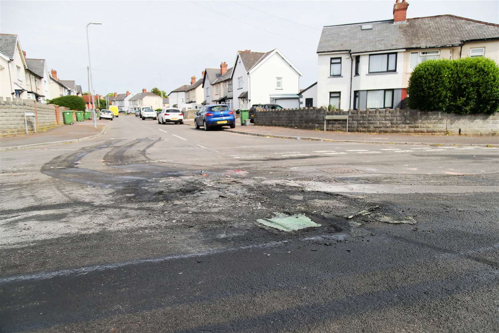 The damaged road surface where a car was set alight in Ely, Cardiff (PA)