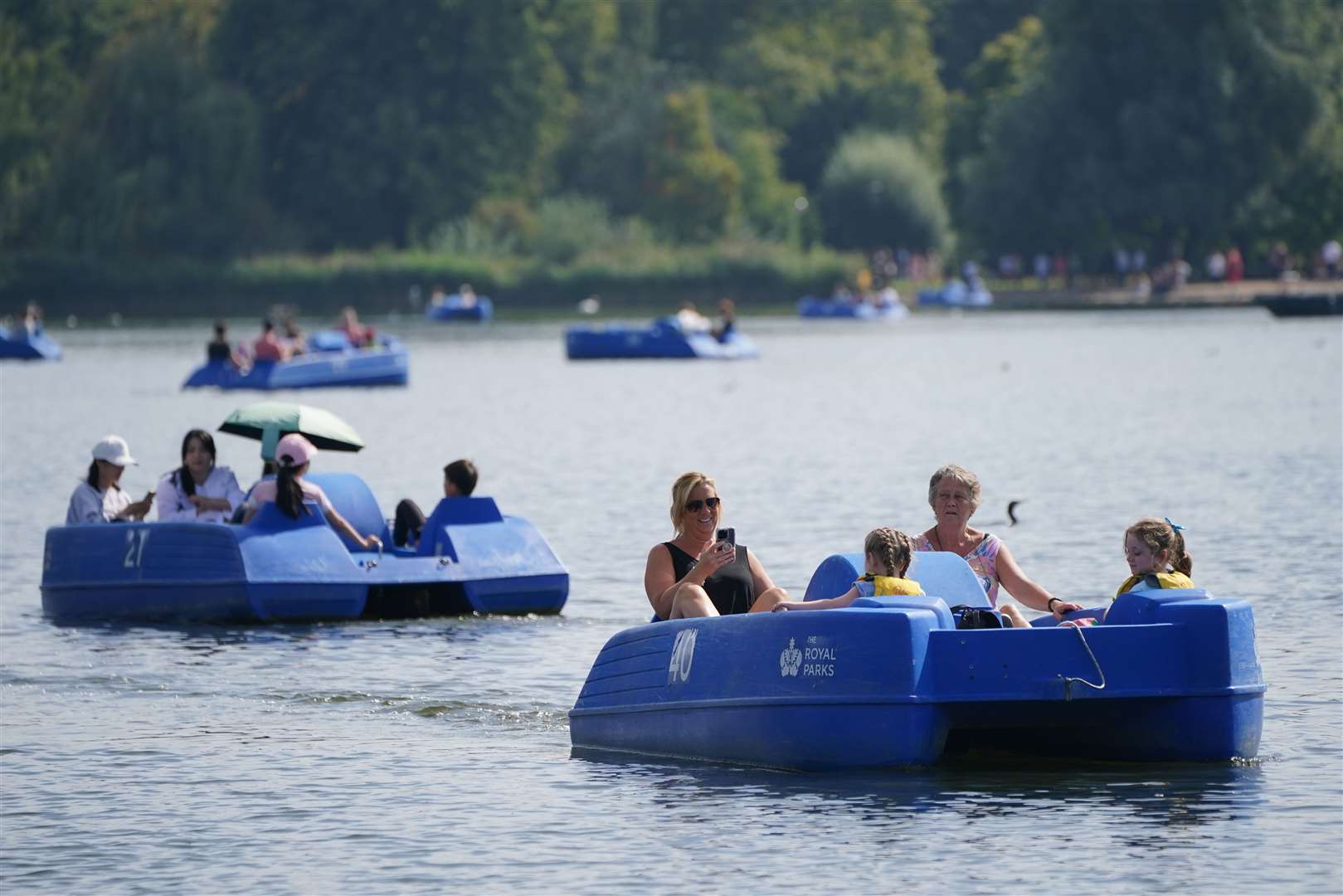 People enjoy the warm weather boating in Hyde Park in central London (Jonathan Brady/PA)