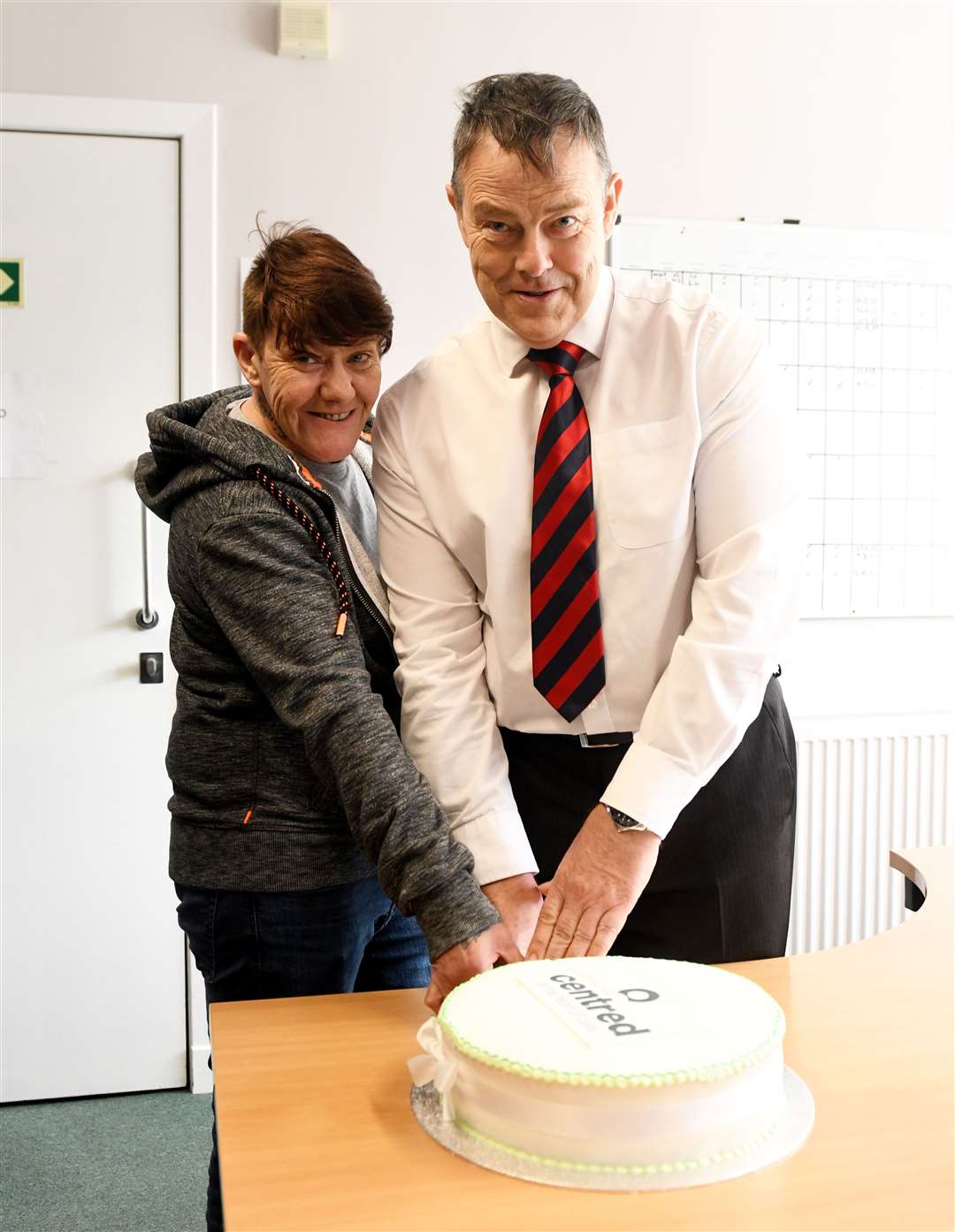 Lainey Anderson and Centred chief executive David Brookfield cut the cake.