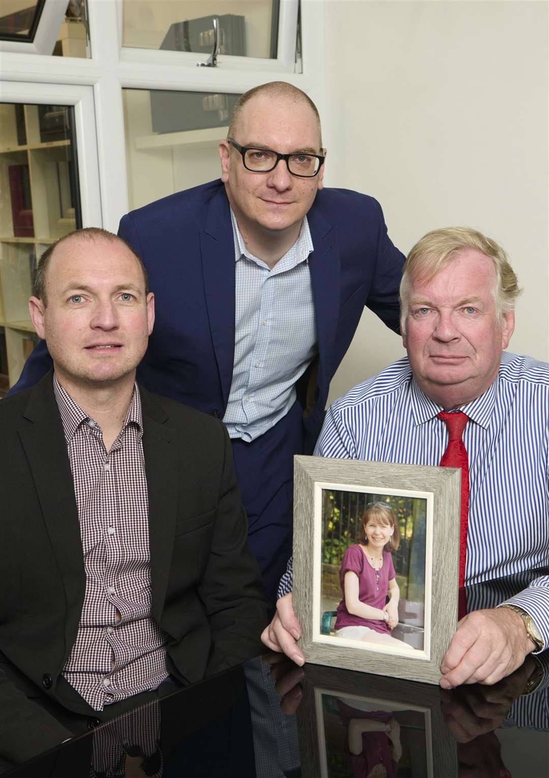 From left: Scott, Chris and David Dowling with a photograph of Jennifer.