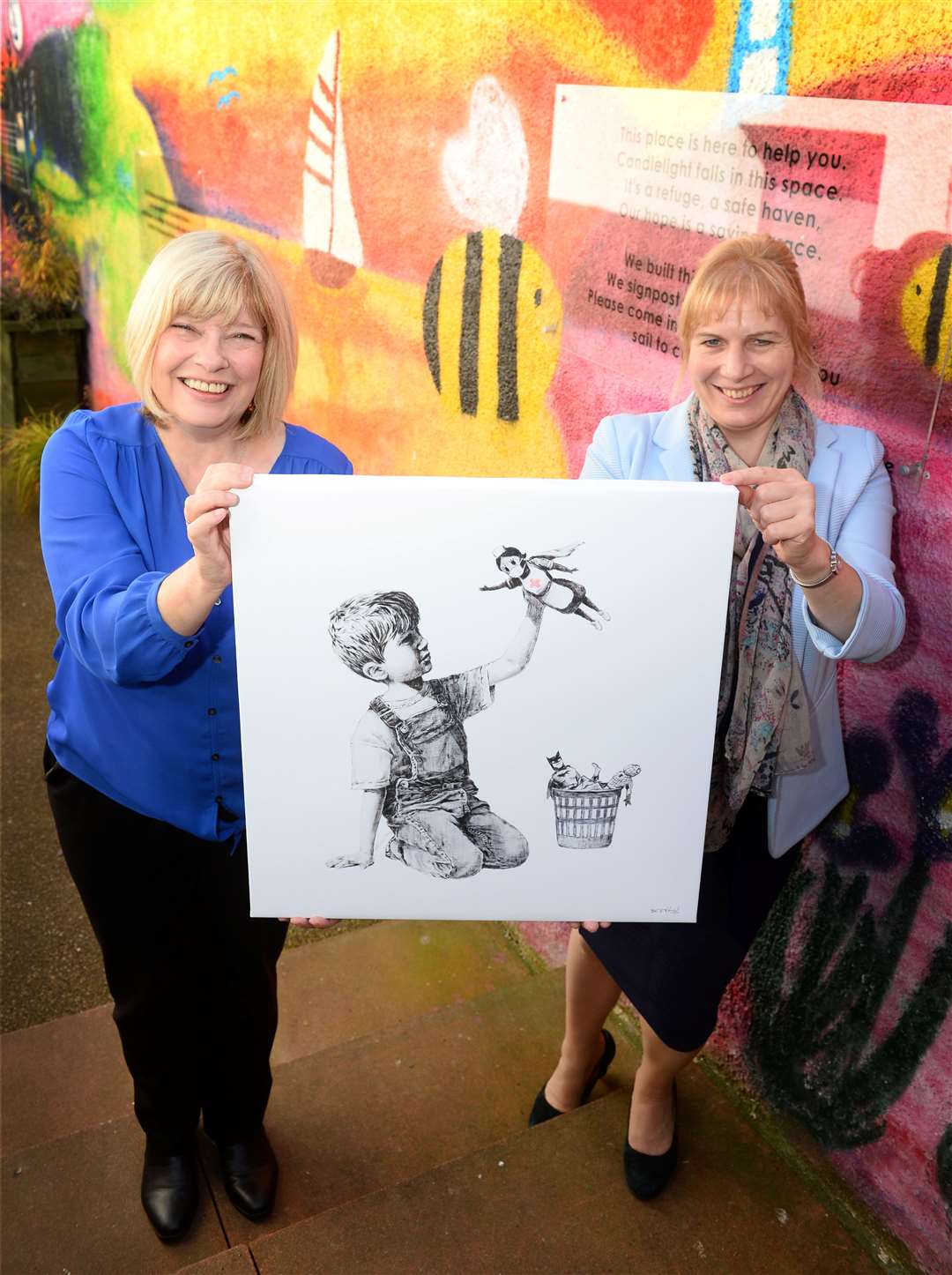 Bonnie McColl and Emily Stokes, of Mikeysline, with the limited edition print of the Banksy artwork, Game Changer. Picture: Gary Anthony.