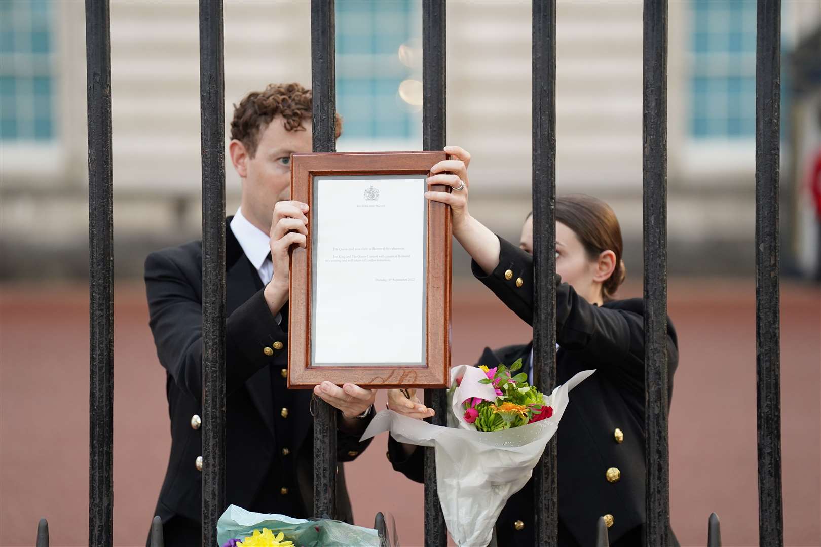 The notice announcing the death of Queen Elizabeth II is removed from the gates of Buckingham Palace (James Manning/PA)