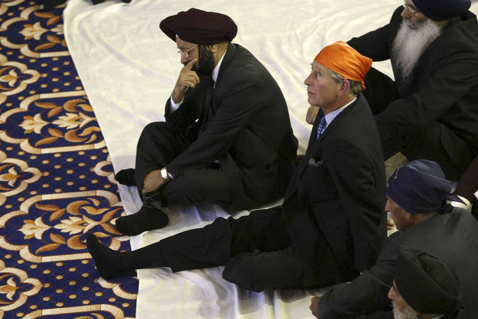 The Prince of Wales joked he found it difficult to sit on the floor while visiting the Sri Guru Singh Sabha Gurdwara Sikh Temple, in Southall, in 2003 (PA)