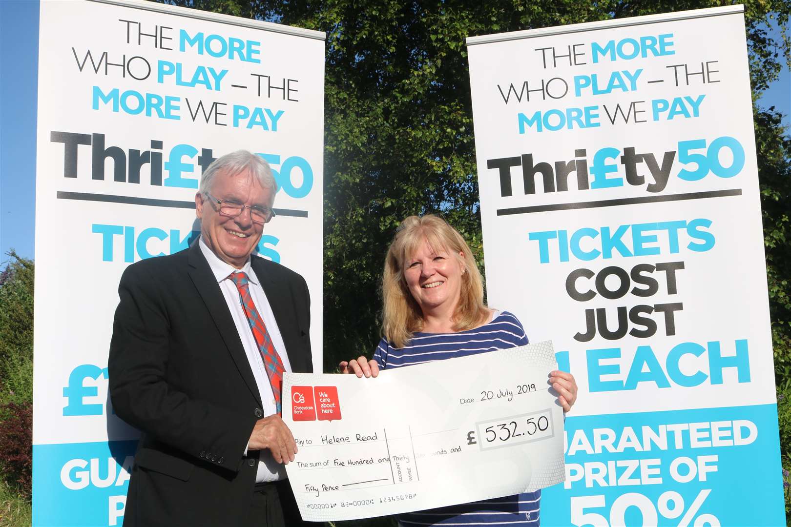 Deputy Provost Graham Ross presents Helene Read of Avoch with the first ever Thrifty50 Prize of £532.50. Helene's winning ticket was 476.