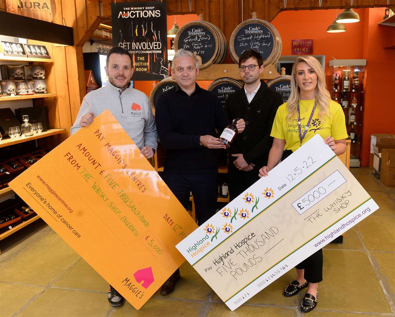 Andrew Benjamin of Maggie's Highland and Karen Duff of Highland Hospice receive £5000 each from Darren Leitch and Brett Gleed of the Whisky Shop. Picture: Gary Anthony