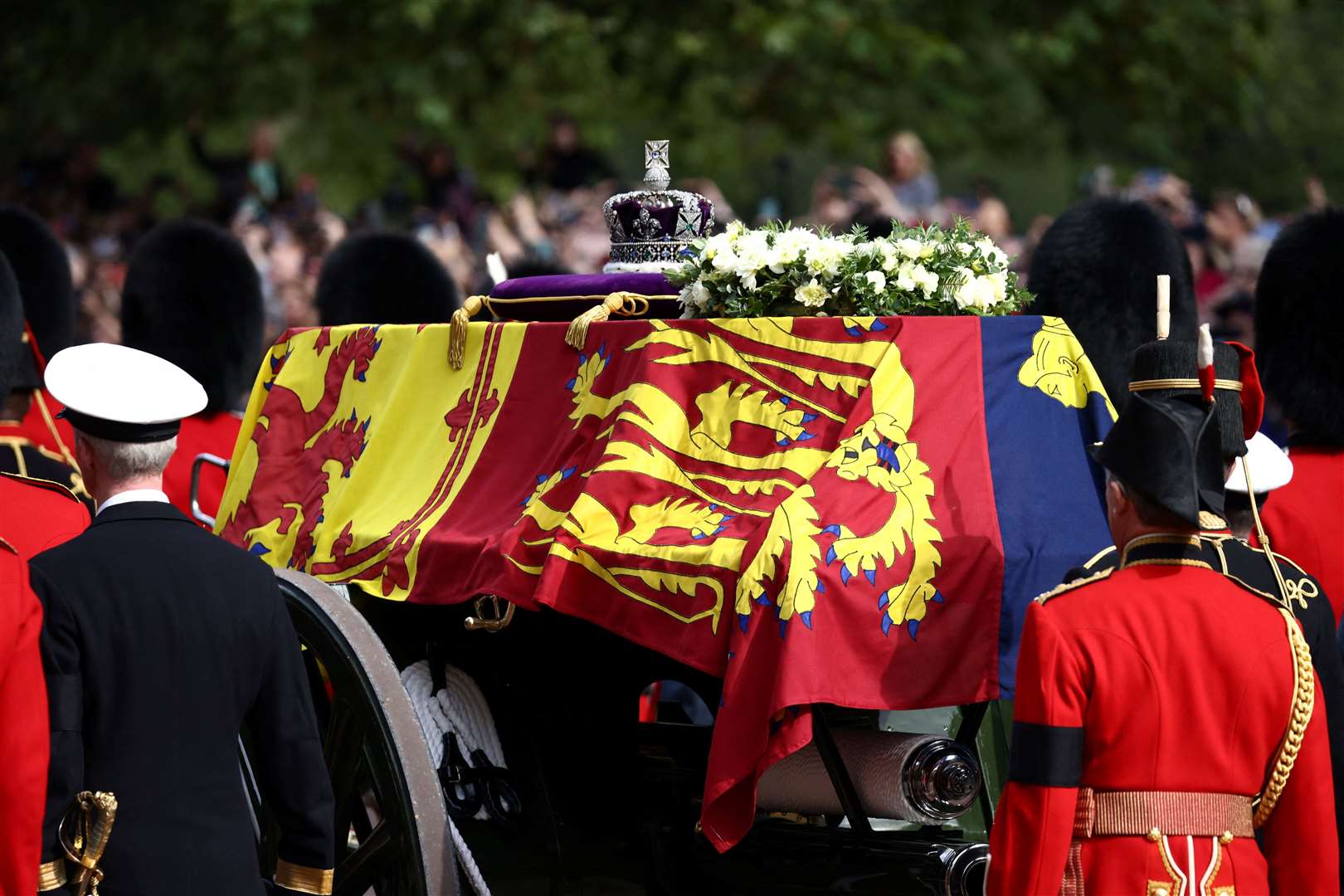 The coffin of the Queen, draped in the Royal Standard with the Imperial State Crown placed on top, is carried on a horse-drawn gun carriage of the King’s Troop Royal Horse Artillery during the ceremonial procession from Buckingham Palace to Westminster Hall (Henry Nicholls/PA)