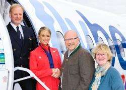 Flybe Captain Paul Carter and cabin crew member Danni Docherty welcome first passengers Jan and Sigga Overmeer from Lochcarron on board the first Inverness to Amsterdam flight.