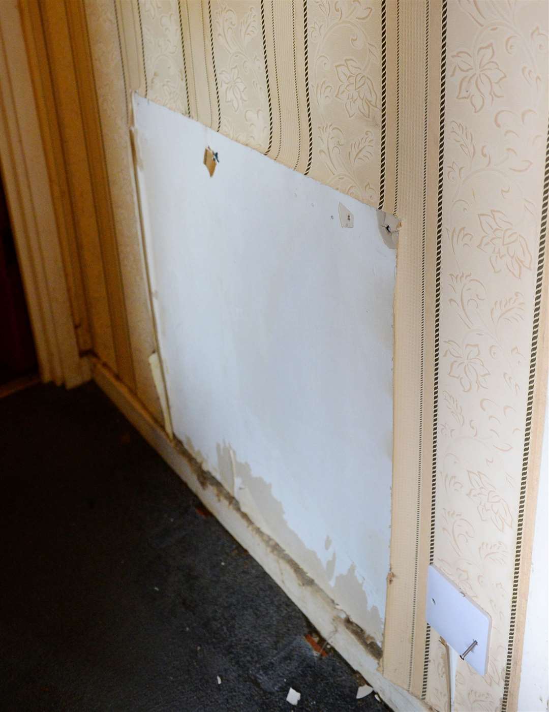 John Ballie is unhappy with damge after fitting of new heating system.Wallpaper hanging off where old radiator was removed.Picture Gary Anthony.