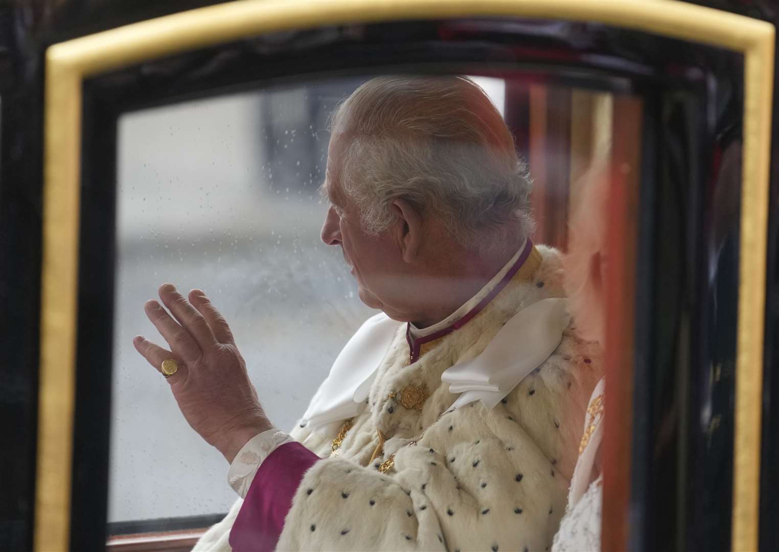 The King waves to the crowd as he travels in the Diamond Jubilee State Coach on Coronation day (Mosa’ab Elshamy/PA)