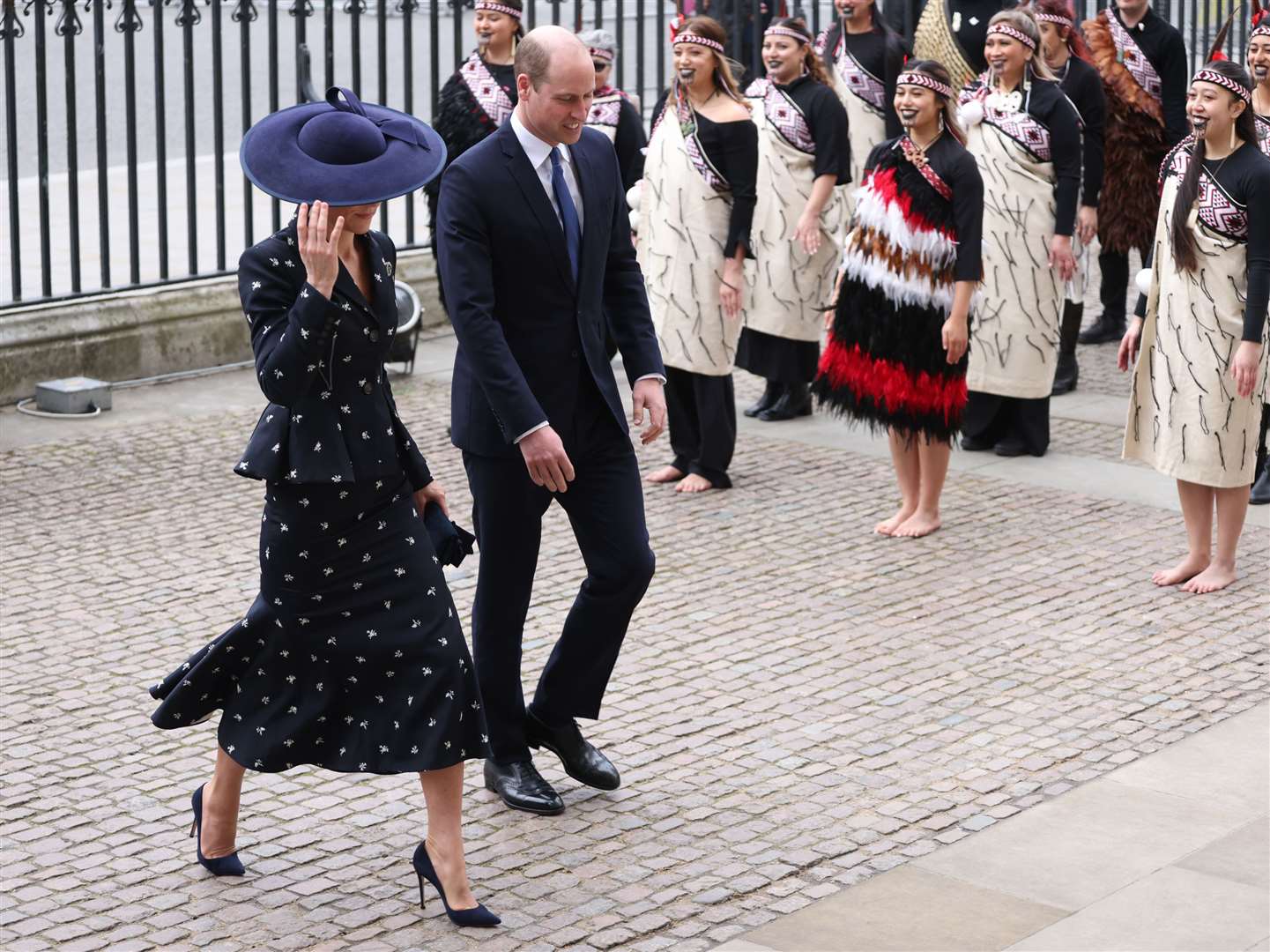 The Princess of Wales holds onto her hat as she arrives with the Prince of Wales (Belinda Jiao/PA)