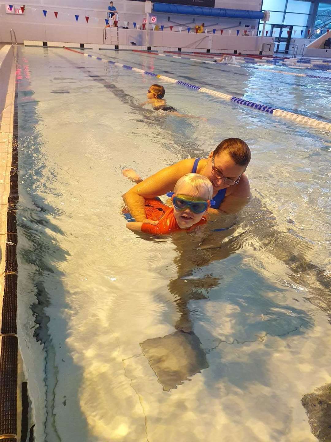Little Fergus powers up the pool with some help from his mum.