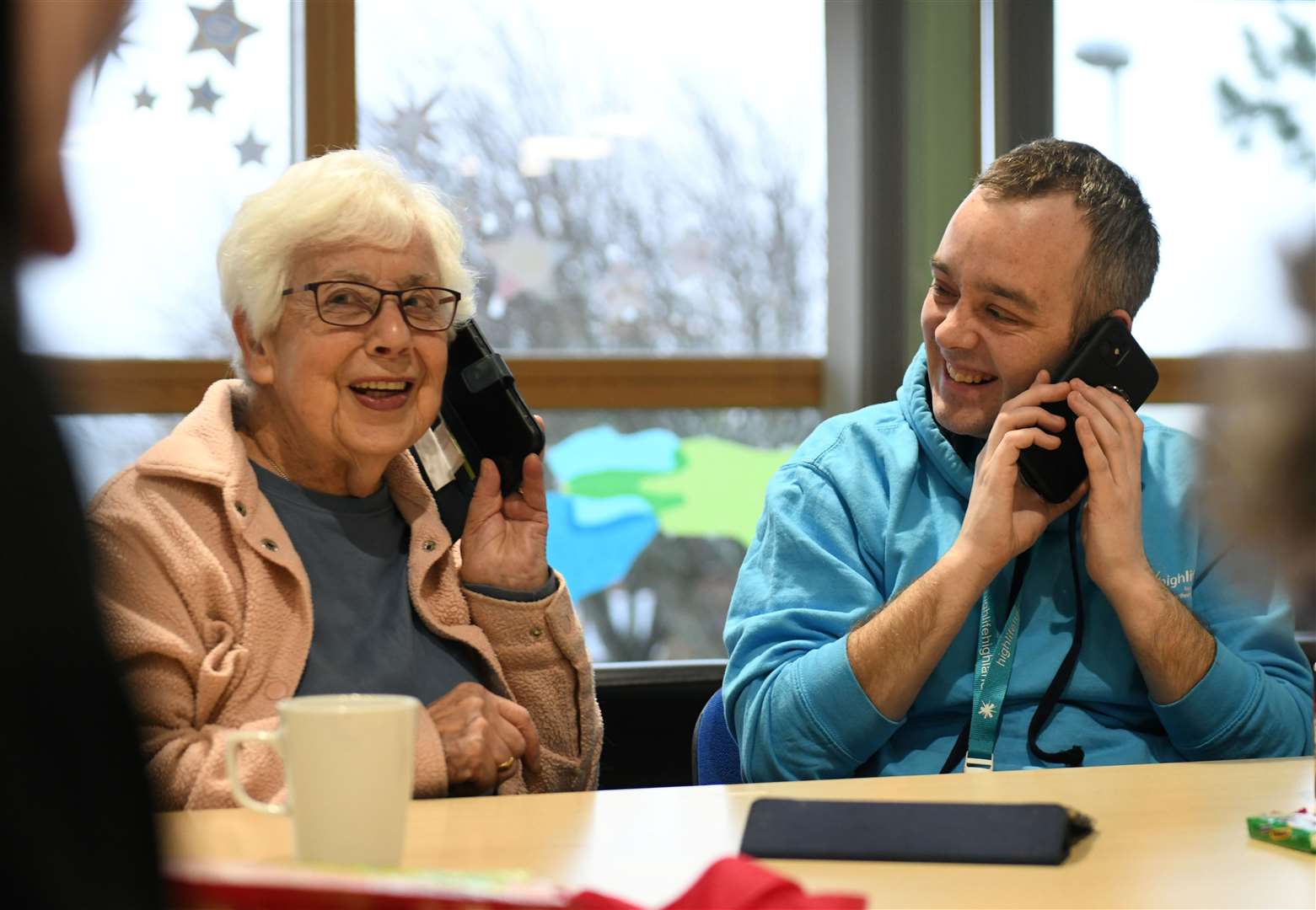 Moira Anderson getting help with her mobile phone from Fraser Thomson from High Life Highland. Picture: James Mackenzie.