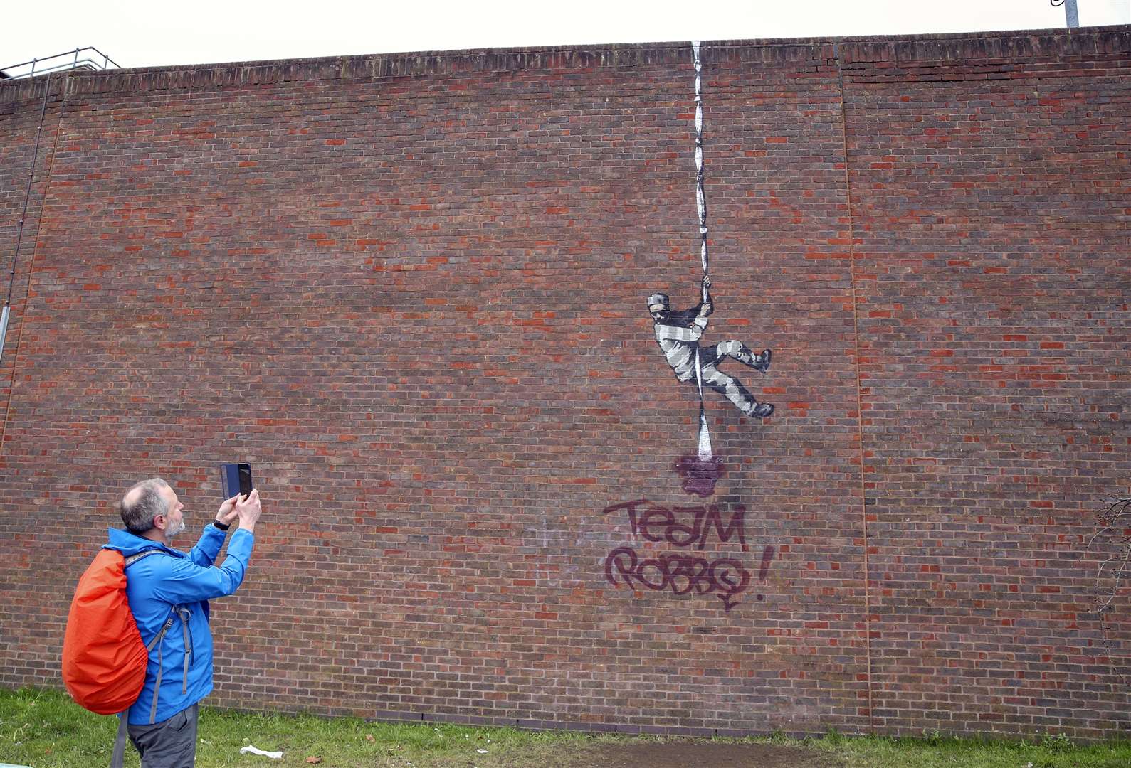 The Banksy artwork which was painted on the side of the former prison in Reading has now been defaced (Steve Parsons/PA)