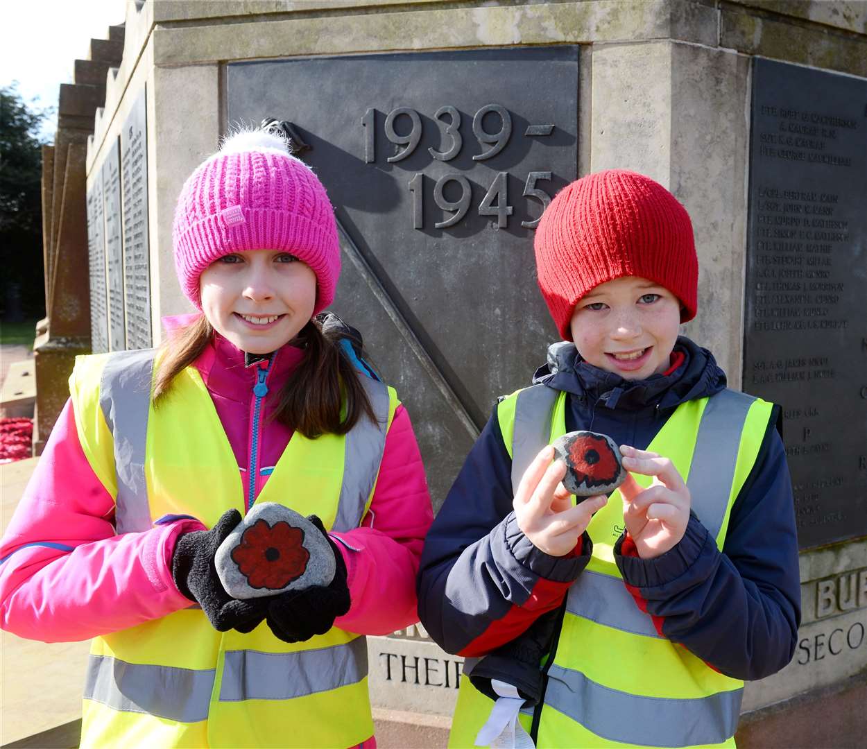 P5 pupils Caitlyn Robertson and Lewis McDonell, of Holm Primary School, place decorated pebbles at memorial.