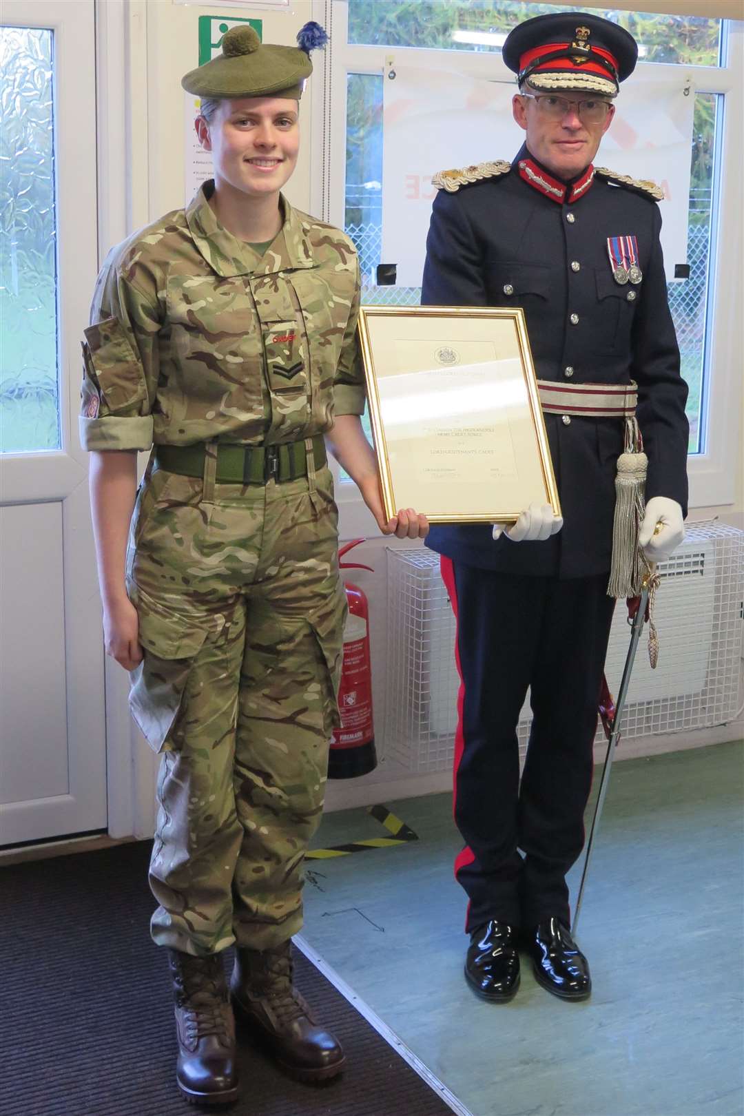 Cpl Darcey Woodman (left) receiving her certificate of appointment from the Lord Lieutenant of Nairnshire.