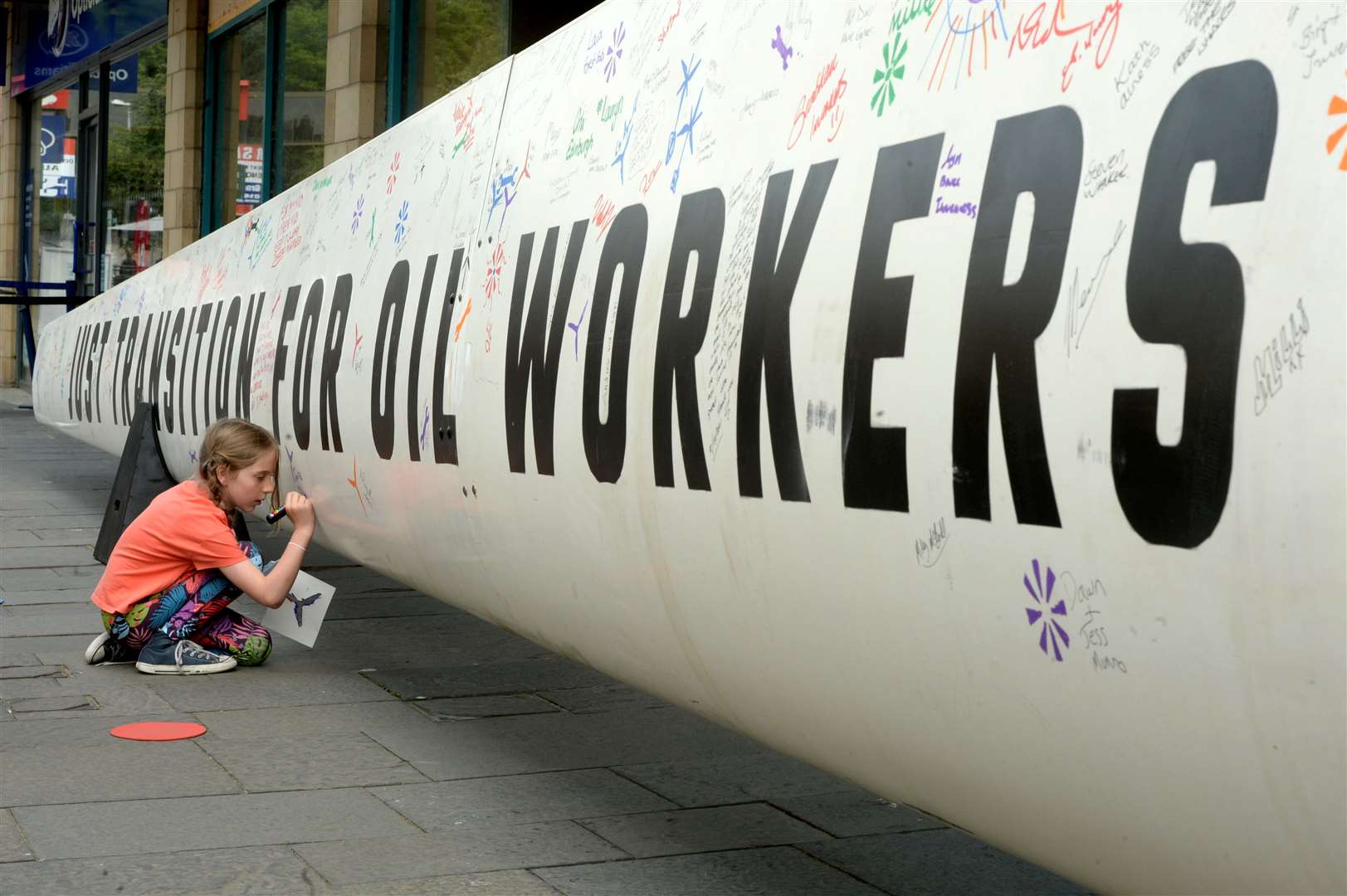 Greenpeace station a 13ft wind turbine blade outside the Eastgate centre as part of pressure on Nicola Sturgeon regarding the transition from oil and gas to renewables: Jane Mackenzie (8) adding her signature to the wind turbine blade. Picture: James Mackenzie