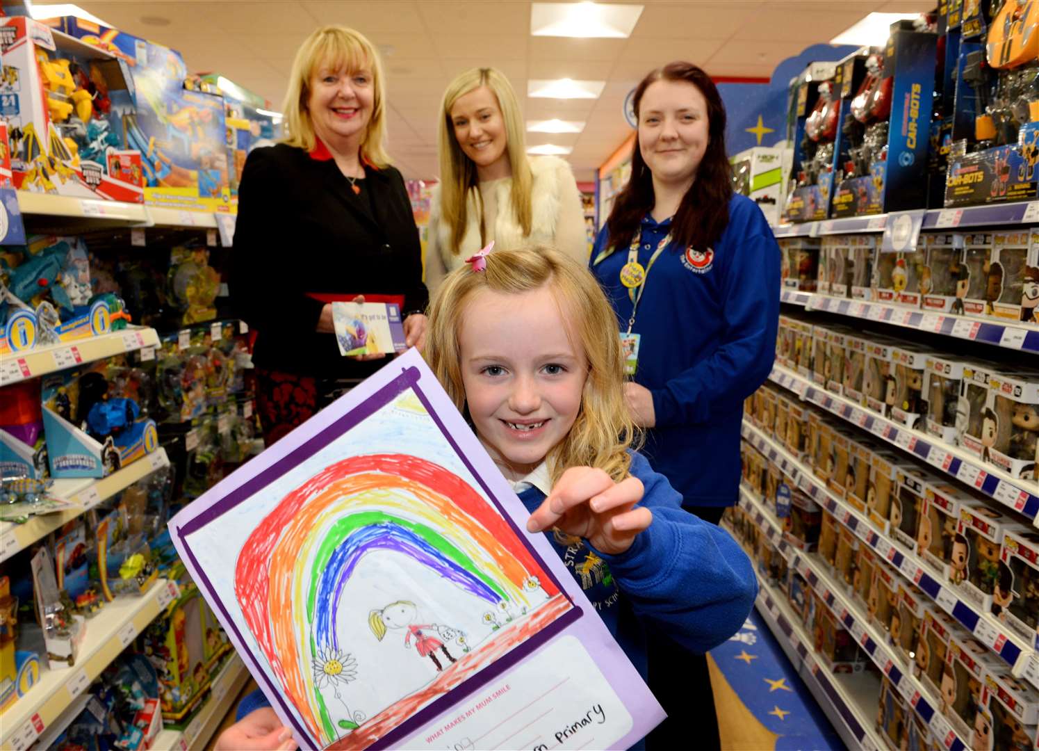 Millie Mackenzie from Strathdearn Primary with mum Angela (centre)receives vouchers from Jackie Cuddy (Eastgate Shopping Centre) and Chloe Elder (The Entertainer). Picture: Gary Anthony. Image No. 043625.