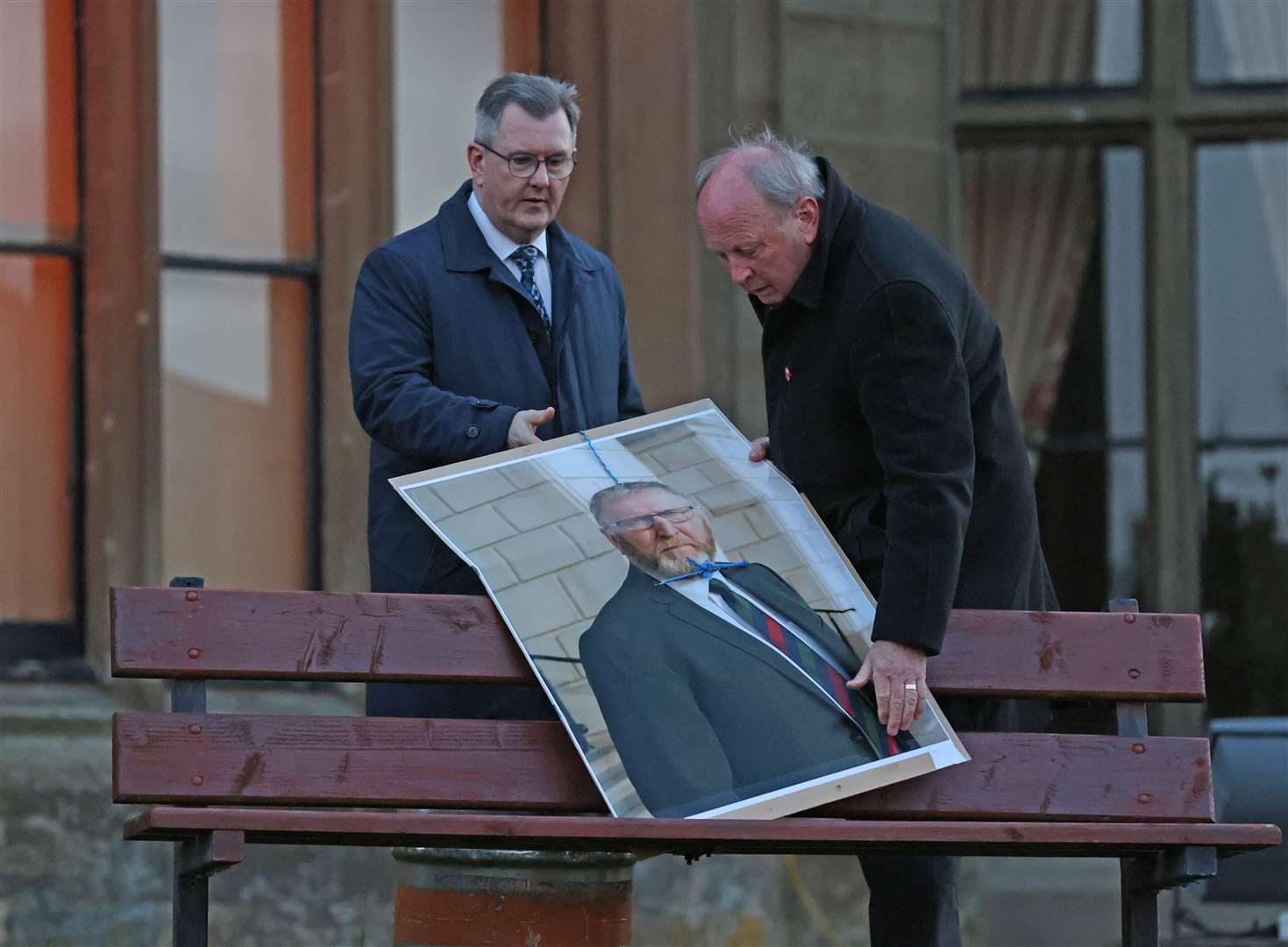 Jim Allister and DUP leader Sir Jeffrey Donaldson remove a poster of the leader of the Ulster Unionist Party, Doug Beattie, with a noose at a rally in Lurgan in April 2022 (PA)