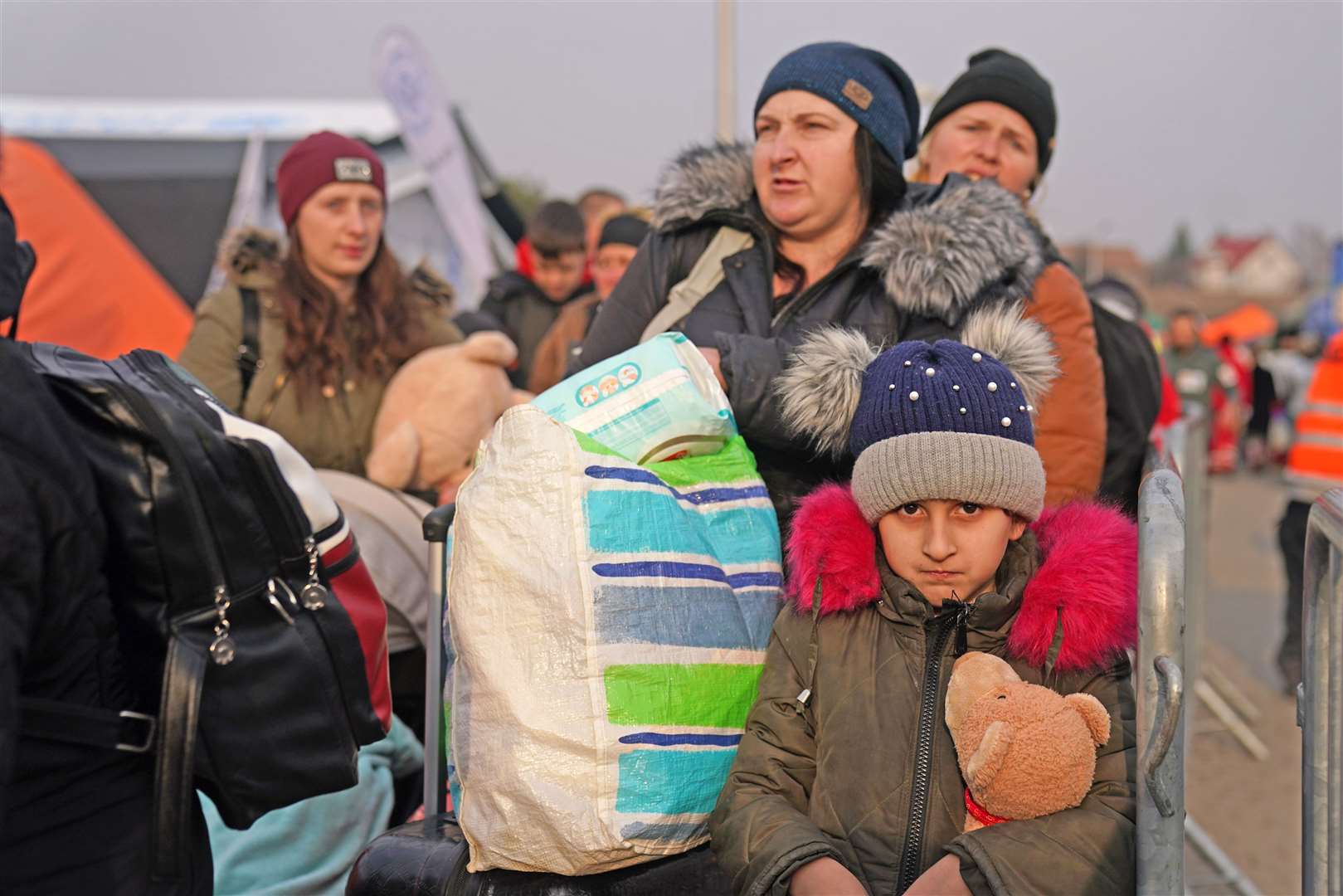 People who have crossed the border point from Ukraine into Medyka, Poland, wait to board a bus (Victoria Jones/PA)