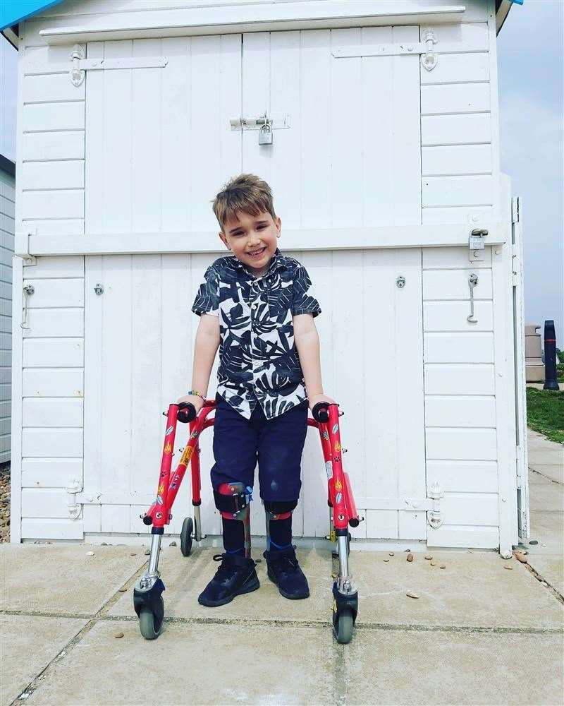 WALKING TALL: Harry Ragless has raised £2,400 with the help of his father and his walking frame and leg supports.
