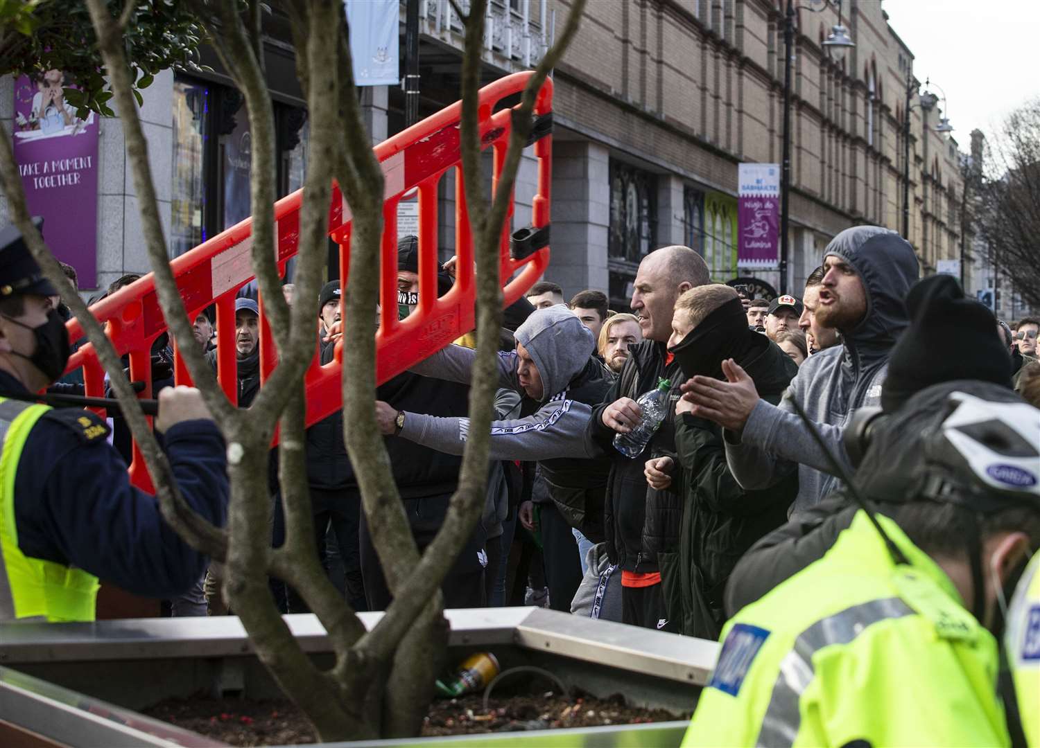 A protestor throws a plastic barrier at Garda on Grafton Street in Dublin at an anti lockdown protest on February 27 (Damen Eagers/PA)