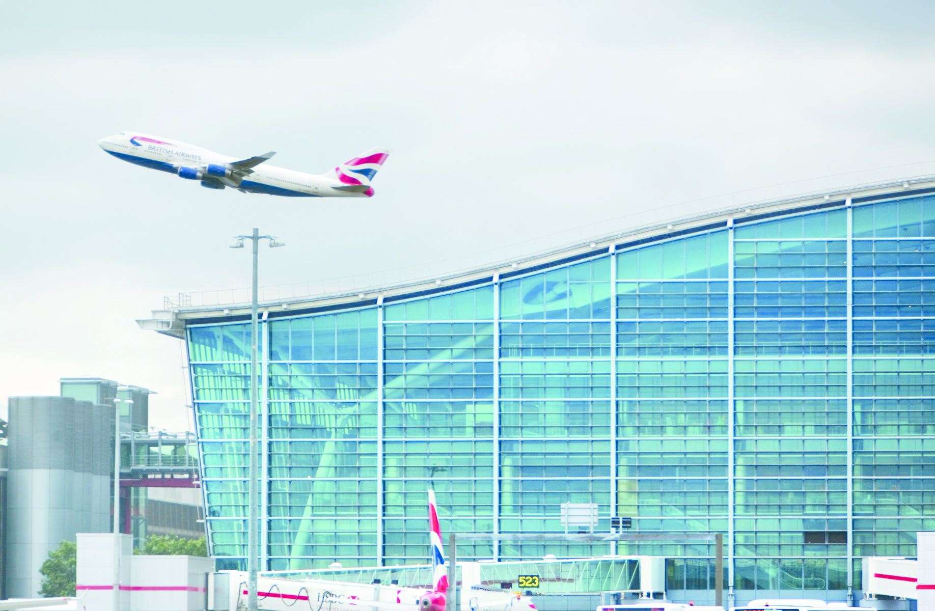 Heathrow Airport, Terminal 5A (main terminal building - southern elevation), British Airways Boeing 747 taking off in background, August 2010.