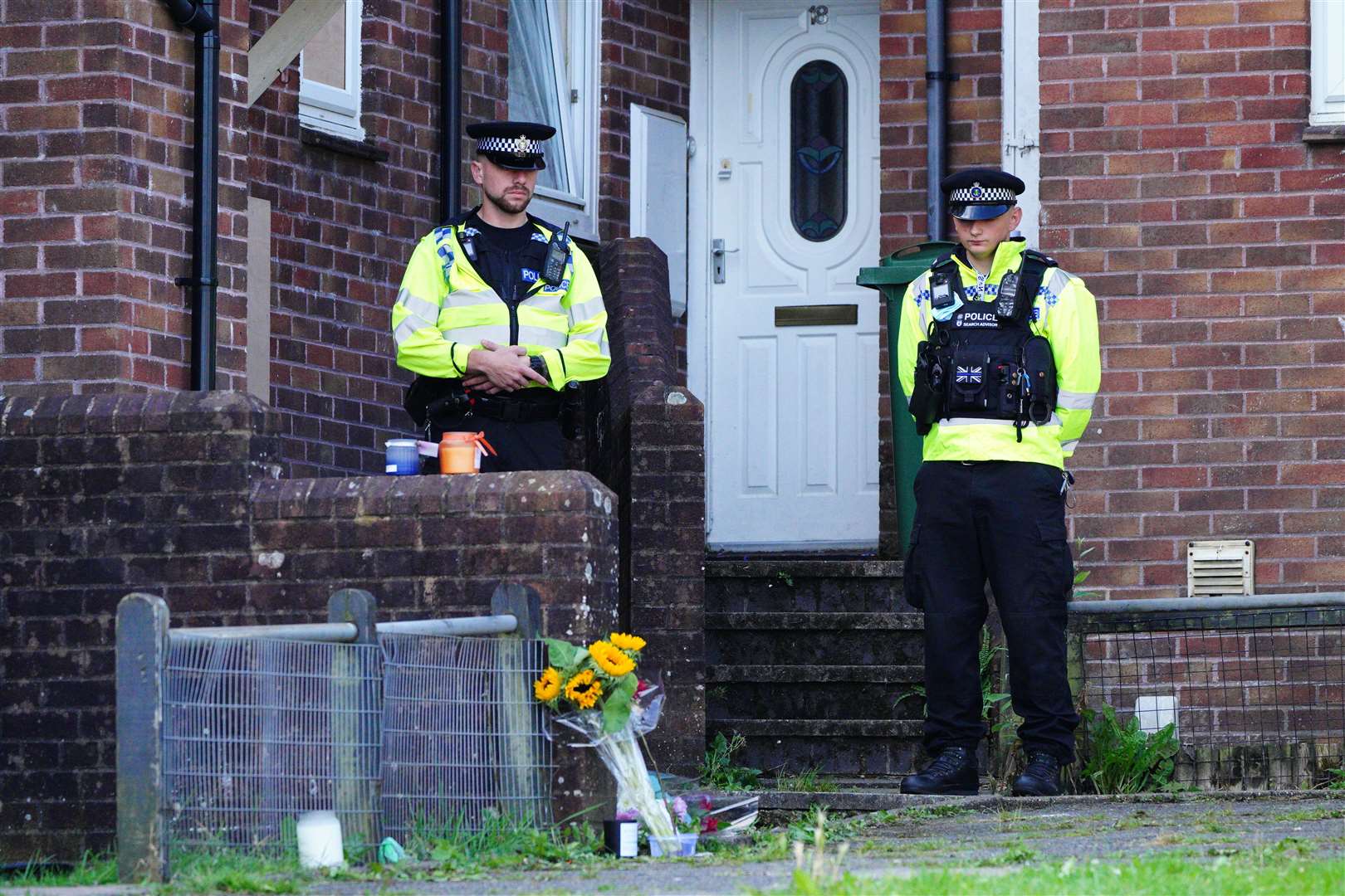 Floral tributes left outside an address in Biddick Drive as police stand guard (Ben Birchall/PA)