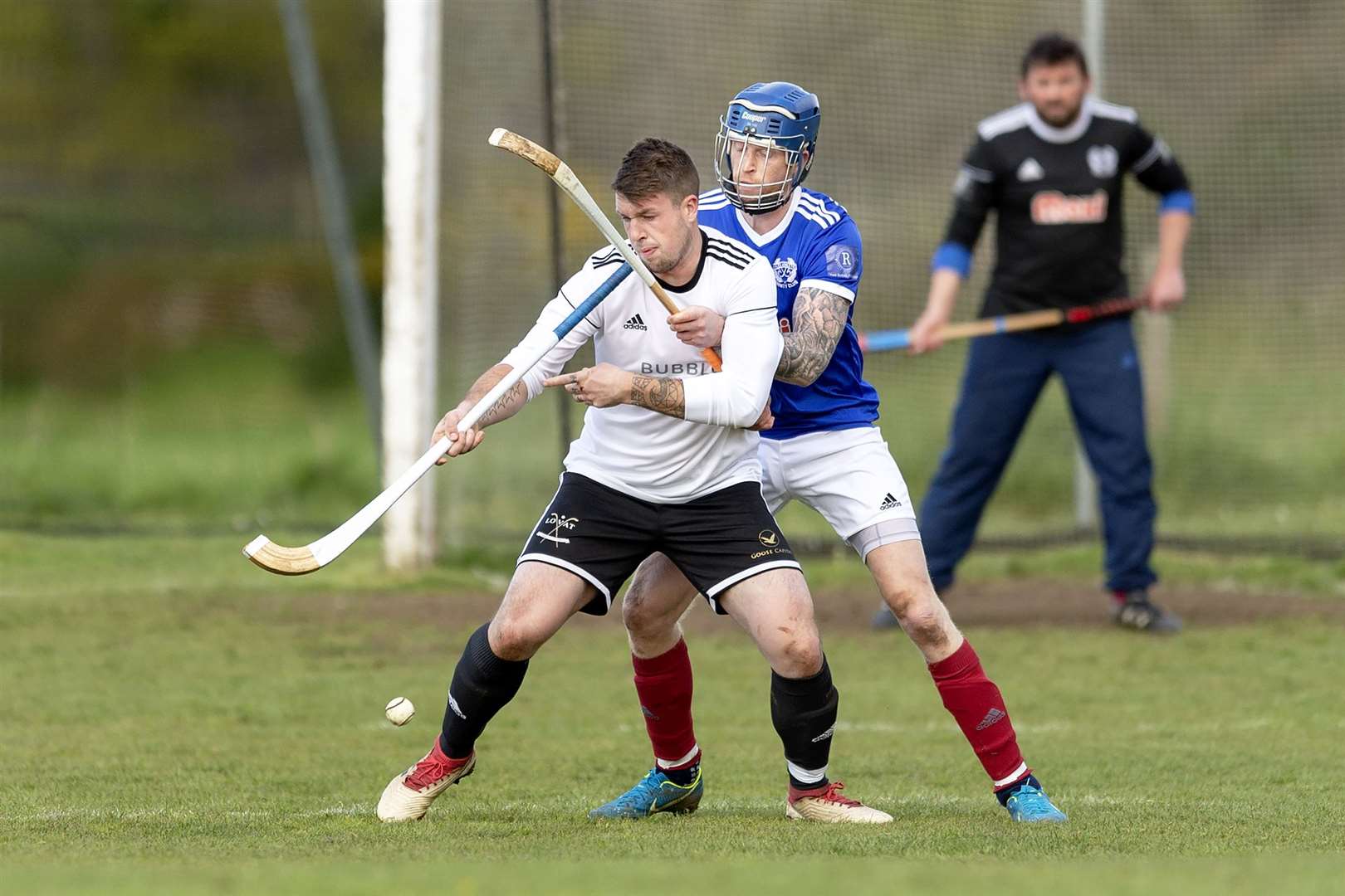 Marc MacLachlan (Lovat) is closely marked by Roddy Macdonald (Kyles). Lovat v Kyles Athletic in the MOWI Premiership, played at Balgate, Kiltarlity.