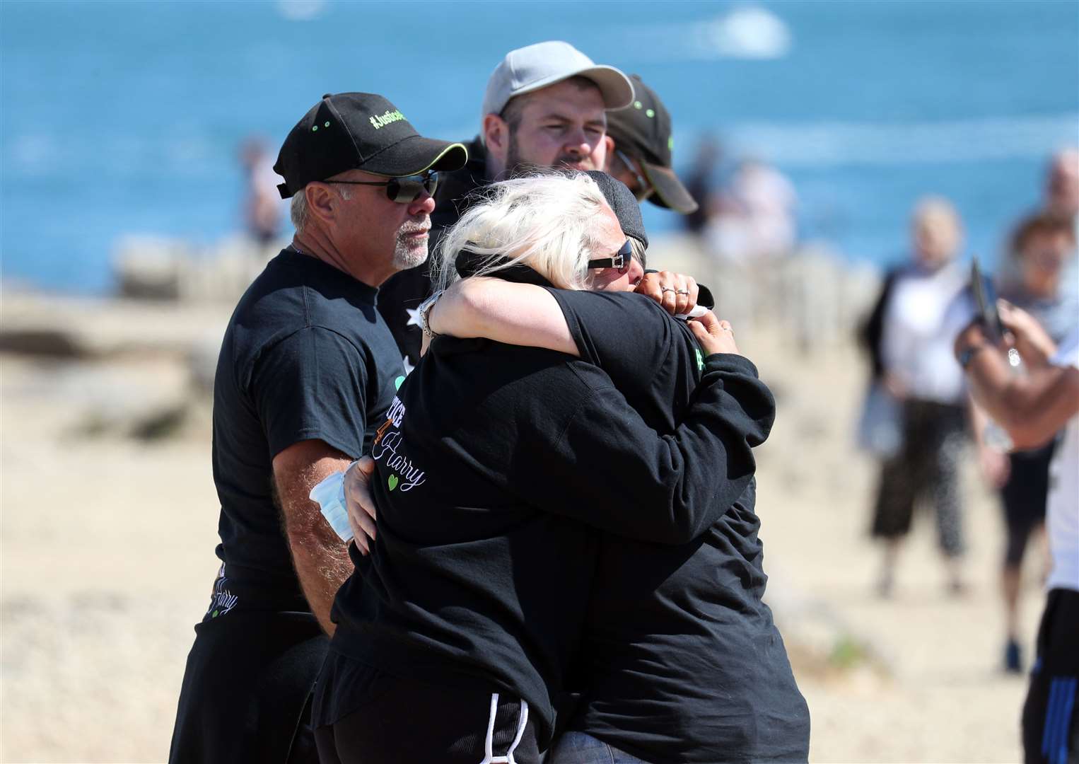 Charlotte Charles is embraced after she gathered with friends and family at Portland Bill to scatter her son’s ashes in his favourite place in Weymouth, Dorset, a month before the anniversary of his death (Andrew Matthews/PA)