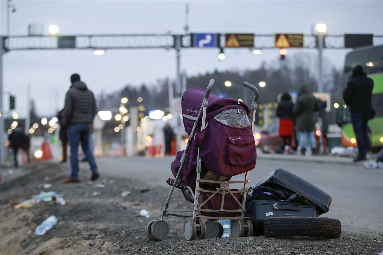 An abandoned suitcase and pushchair left beside the road as Ukrainian refugees flee Russian invasion at a border crossing in Medyka, Poland (Visar Kryeziu/AP)