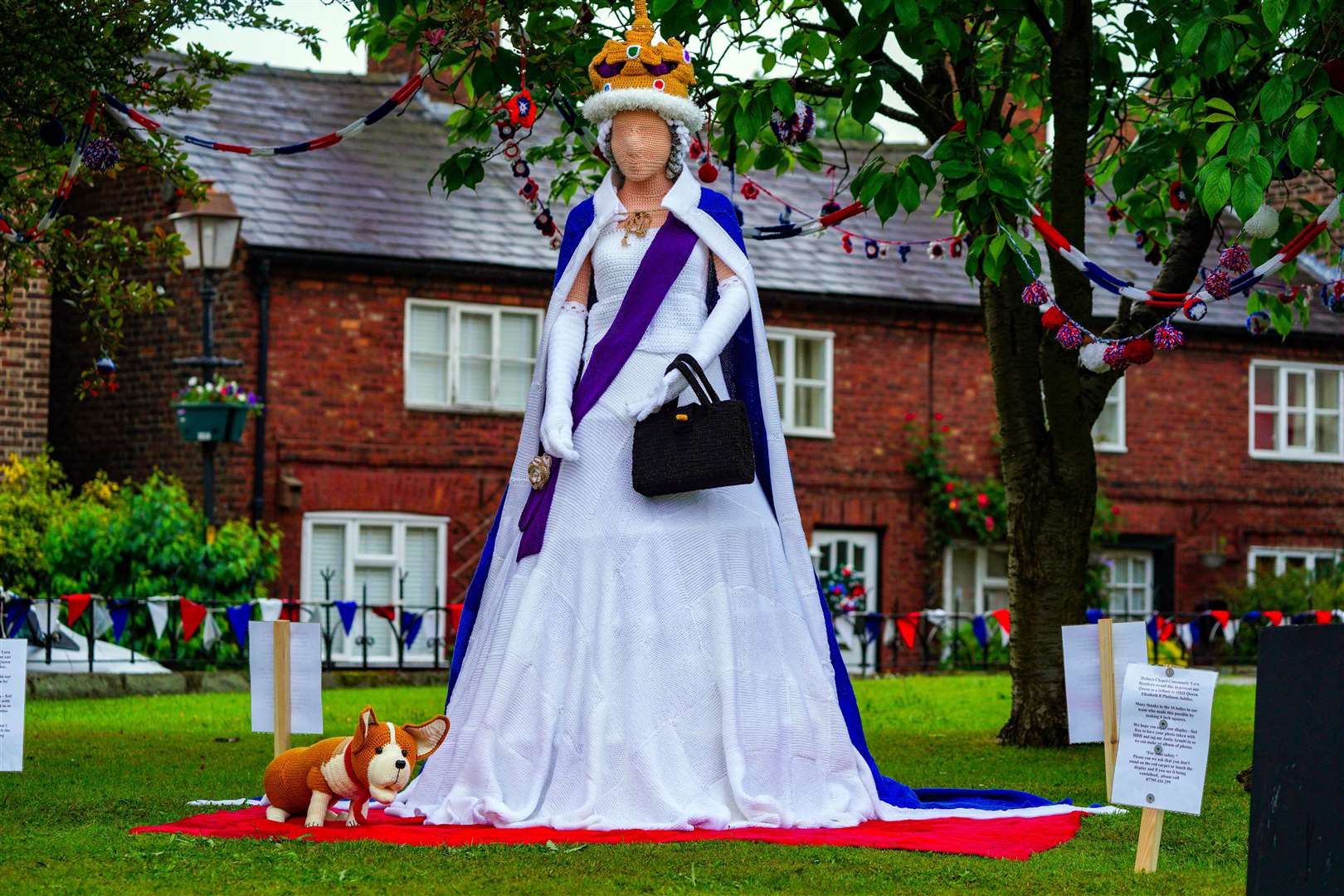 A life-sized knitted Queen and corgi in the village of Holmes Chapel in Cheshire (Peter Byrne/PA)