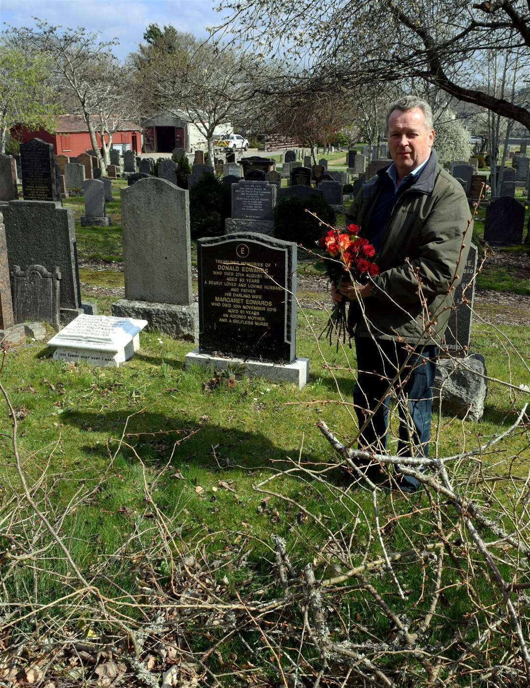 Mike Edwards in front of the grave of grandparents James Edwards and Joey Maclennan and parents Donald and Margaret Edwards.