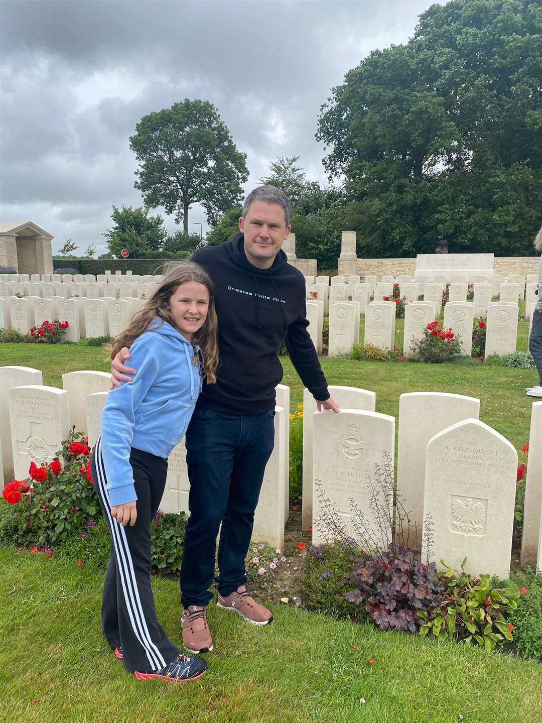 Alex Fisher and his daughter in the cemetery where the RAF crew members including James Hamilton Ross are buried.