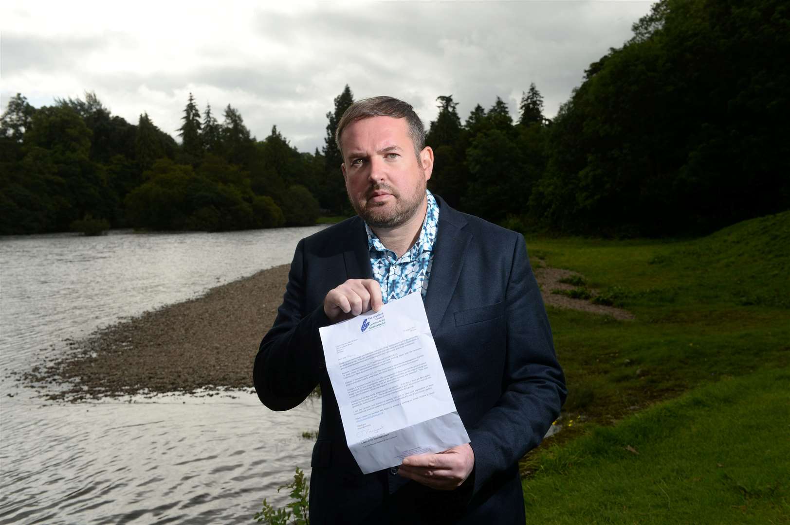 Ron MacWilliam at the site planned for My Ness artwork, with the letter from council leader Margaret Davidson. Picture: Callum Mackay Image No. 044648